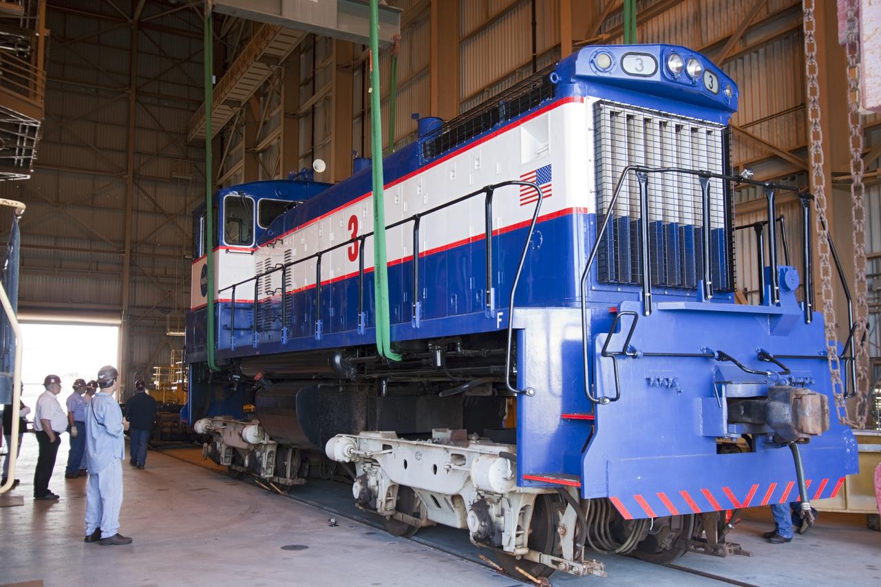 CAPE CANAVERAL, Fla. – Inside the Rotation, Processing and Surge Facility, or RPSF, at the Kennedy Space Center in Florida, an overhead crane lifts NASA locomotive No. 3 moving it into position atop the trucks previously used by locomotive No. 2. The RPSF was built to support work on the solid rocket used motors during the space shuttle era. The facility had never previously been used for another purpose, but is now free to serve other customers. With rails running into the building's high bay and a pair of heavy-lift cranes positioned overhead, the facility's capabilities were a perfect fit for the NASA Railroad's needs. Railroad managers wanted to trade the wheel and axle assemblies, or trucks, of locomotives No. 2 and No. 3. Locomotive No. 3 was painstakingly restored in recent years by the NASA Railroad team, and handles much of the rail work required at the center in the post-shuttle era. But the trucks on locomotive No. 2 are in better shape and are more environmentally friendly. For more information, visit: http://www.nasa.gov/exploration/systems/ground/rpsf_locomotives.html Photo credit: NASA/Jim Grossmann
