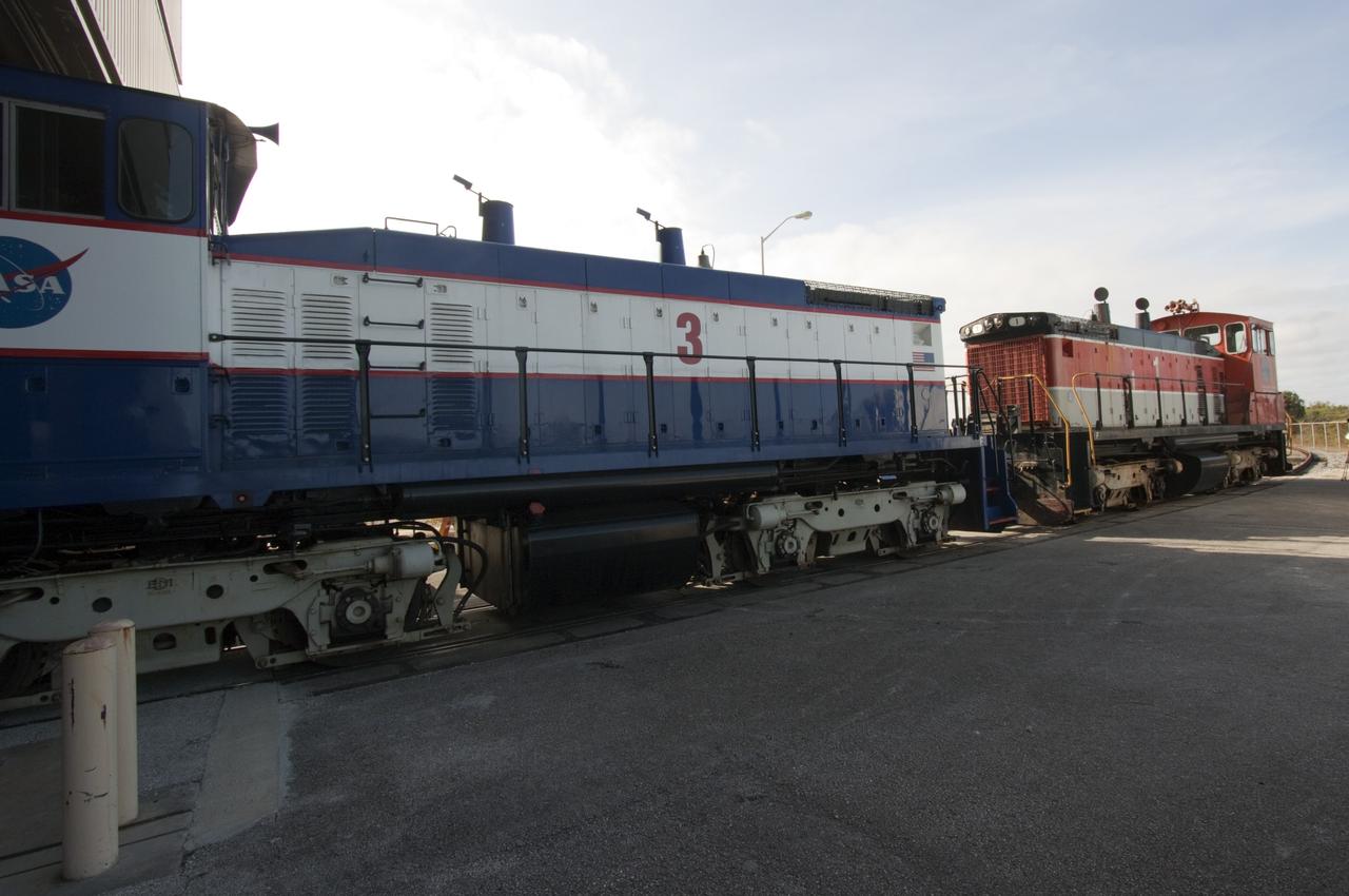 CAPE CANAVERAL, Fla. – NASA locomotive No. 1 pulls locomotive No. 3 out of the Rotation, Processing and Surge Facility, or RPSF, at the Kennedy Space Center in Florida. Inside, an overhead crane was used to lift NASA locomotive No. 2 off of its trucks and moved aside, so locomotive No. 3 could be raised off its trucks and moved into position atop the trucks previously used by locomotive No. 2.       The RPSF was built to support work on the solid rocket used motors during the space shuttle era. The facility had never previously been used for another purpose, but is now free to serve other customers. With rails running into the building's high bay and a pair of heavy-lift cranes positioned overhead, the facility's capabilities were a perfect fit for the NASA Railroad's needs. Railroad managers wanted to trade the wheel and axle assemblies, or trucks, of locomotives No. 2 and No. 3. Locomotive No. 3 was painstakingly restored in recent years by the NASA Railroad team, and handles much of the rail work required at the center in the post-shuttle era. But the trucks on locomotive No. 2 are in better shape and are more environmentally friendly. For more information, visit: http://www.nasa.gov/exploration/systems/ground/rpsf_locomotives.html Photo credit: NASA/Jim Grossmann