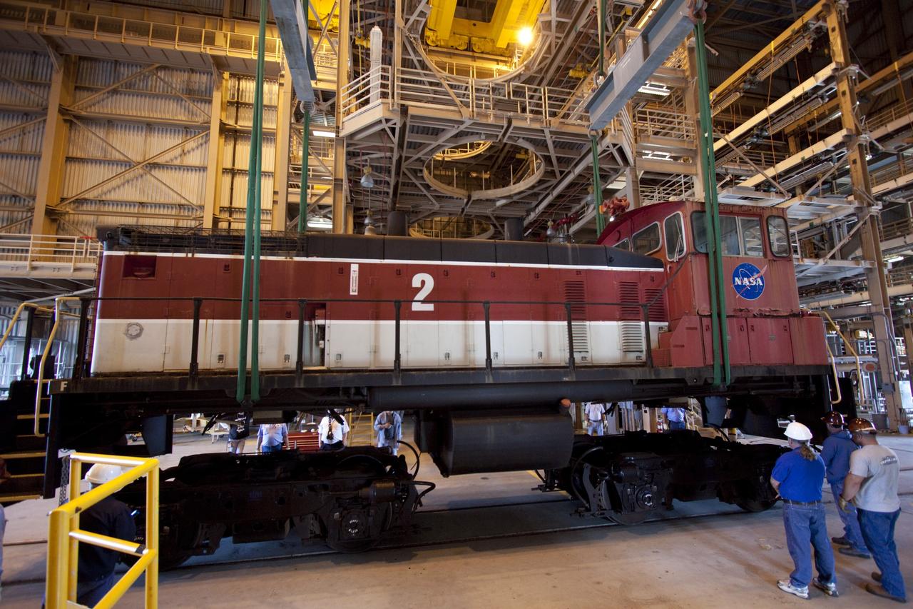 CAPE CANAVERAL, Fla. – NASA locomotive No. 1 pulls locomotive No. 3 out of the Rotation, Processing and Surge Facility, or RPSF, at the Kennedy Space Center in Florida. Inside, an overhead crane was used to lift NASA locomotive No. 2 off of its trucks and moved aside, so locomotive No. 3 could be raised off its trucks and moved into position atop the trucks previously used by locomotive No. 2.       The RPSF was built to support work on the solid rocket used motors during the space shuttle era. The facility had never previously been used for another purpose, but is now free to serve other customers. With rails running into the building's high bay and a pair of heavy-lift cranes positioned overhead, the facility's capabilities were a perfect fit for the NASA Railroad's needs. Railroad managers wanted to trade the wheel and axle assemblies, or trucks, of locomotives No. 2 and No. 3. Locomotive No. 3 was painstakingly restored in recent years by the NASA Railroad team, and handles much of the rail work required at the center in the post-shuttle era. But the trucks on locomotive No. 2 are in better shape and are more environmentally friendly. For more information, visit: http://www.nasa.gov/exploration/systems/ground/rpsf_locomotives.html Photo credit: NASA/Jim Grossmann
