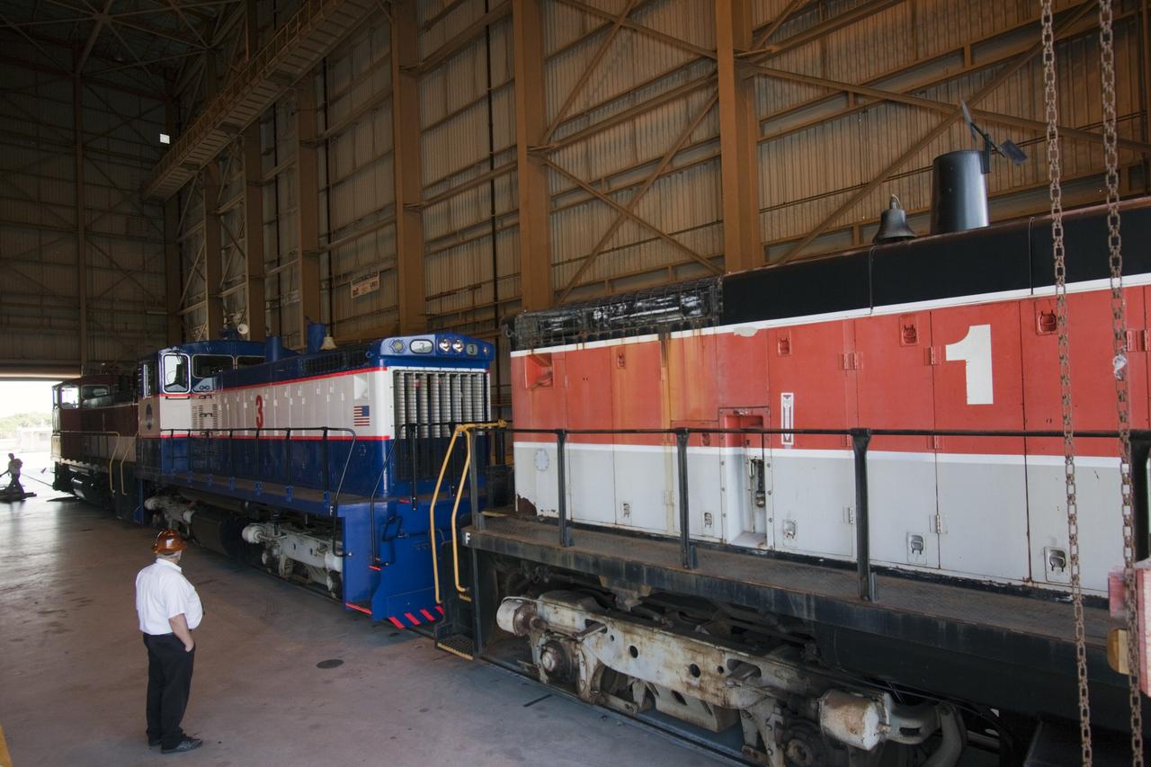 CAPE CANAVERAL, Fla. – Inside the Rotation, Processing and Surge Facility, or RPSF, at the Kennedy Space Center in Florida, NASA locomotive No. 1 pulls locomotives No. 2 and 3 out after wheel and axle assemblies to be swapped between locomotives 2 and 3.      The RPSF was built to support work on the solid rocket used motors during the space shuttle era. The facility had never previously been used for another purpose, but is now free to serve other customers. With rails running into the building's high bay and a pair of heavy-lift cranes positioned overhead, the facility's capabilities were a perfect fit for the NASA Railroad's needs. Railroad managers wanted to trade the wheel and axle assemblies, or trucks, of locomotives No. 2 and No. 3. Locomotive No. 3 was painstakingly restored in recent years by the NASA Railroad team, and handles much of the rail work required at the center in the post-shuttle era. But the trucks on locomotive No. 2 are in better shape and are more environmentally friendly. For more information, visit: http://www.nasa.gov/exploration/systems/ground/rpsf_locomotives.html Photo credit: NASA/Jim Grossmann