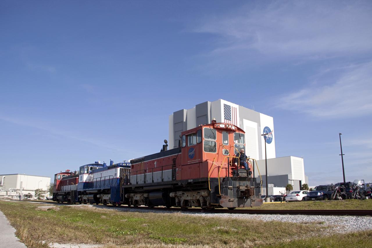 KSC-2012-6359 – CAPE CANAVERAL, Fla. – At Kennedy Space Center in Florida, NASA railroad locomotive No. 1 returns locomotives 2 and 3 to Launch Complex 39 area's rail yard after wheel and axle assemblies were swapped between locomotives 2 and 3. The RPSF was built to support work on the solid rocket used motors during the space shuttle era. The facility had never previously been used for another purpose, but is now free to serve other customers. With rails running into the building's high bay and a pair of heavy-lift cranes positioned overhead, the facility's capabilities were a perfect fit for the NASA Railroad's needs. Railroad managers wanted to trade the wheel and axle assemblies, or trucks, of locomotives No. 2 and No. 3. Locomotive No. 3 was painstakingly restored in recent years by the NASA Railroad team, and handles much of the rail work required at the center in the post-shuttle era. But the trucks on locomotive No. 2 are in better shape and are more environmentally friendly. For more information, visit: http://www.nasa.gov/exploration/systems/ground/rpsf_locomotives.html Photo credit: NASA/Jim Grossmann