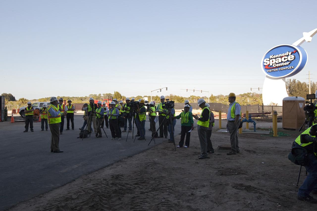 CAPE CANAVERAL, Fla. – Tim Macy, at left, the director of project development and construction for Delaware North Companies Parks & Resorts, speaks to members of the media during an up close viewing of space shuttle Atlantis in her new home at the Kennedy Space Center Visitor Complex in Florida. The shuttle is wrapped in a protective plastic to protect it from dust and debris while being prepared for display. Atlantis was lifted 26 feet from the ground level and slowly tilted to exactly a 43.21 angle to its portside to allow optimum viewing of the vehicle with its payload bay doors open.      Atlantis is being prepared for display in the new 90,000-square-foot facility under construction at the visitor complex which is managed by Delaware North Companies Parks & Resorts. Photo credit: NASA/Dimitri Gerondidakis