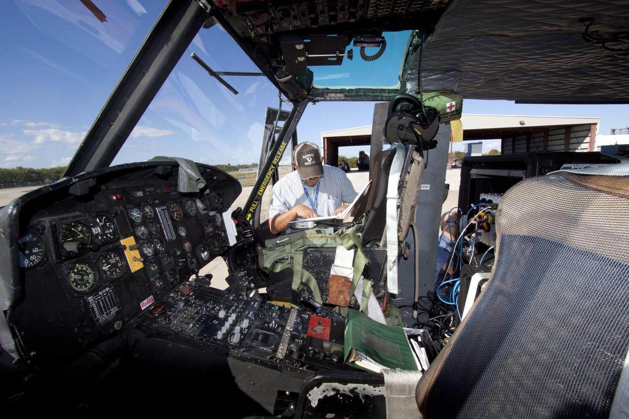 CAPE CANAVERAL, Fla. – Near the Shuttle Landing Facility at NASA's Kennedy Space Center in Florida, a technician tests hazard avoidance instrumentation recently installed on a Huey helicopter. Led by the Johnson Space Center and supported by Jet Propulsion Laboratory and Langley Research Center, the Autonomous Landing Hazard Avoidance Technology, or ALHAT, laser system provides a planetary lander the ability to precisely land safely on a surface while detecting any dangerous obstacles such as rocks, holes and slopes. Just north of Kennedy's Shuttle Landing Facility runway, a rock- and crater-filled planetary scape has been built so engineers can test the ability to negotiate away from risks. Photo credit: NASA/Jim Grossmann