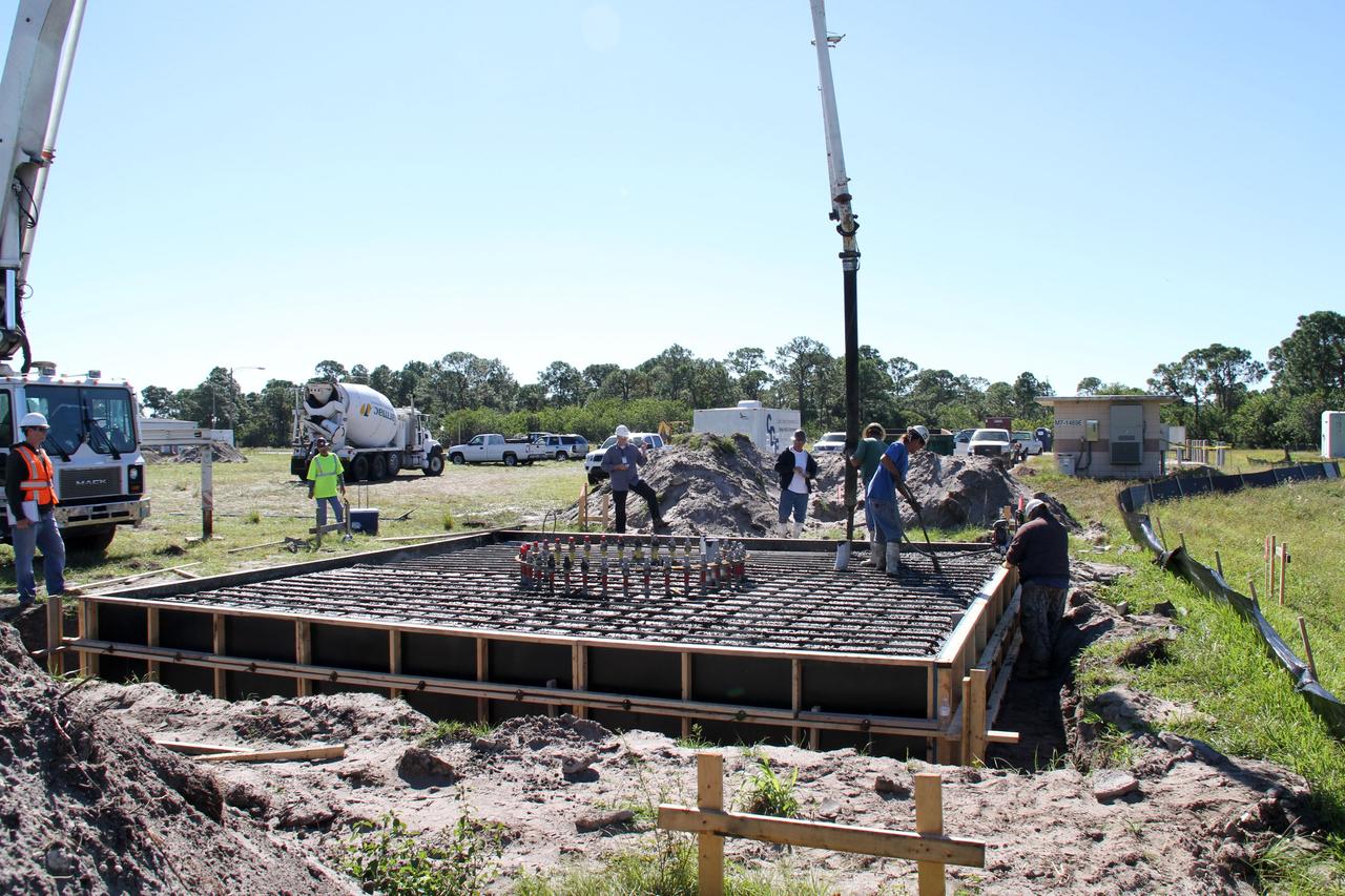 CAPE CANAVERAL, Fla. – At NASA’s Kennedy Space Center in Florida, workers pour concrete at the base of the site of the Antenna Test Bed Array for the Ka-Band Objects Observation and Monitoring, or Ka-BOOM system.    The construction site is near the former Vertical Processing Facility, which has been demolished. Workers are placing the pile foundations for the 40-foot-diameter dish antenna arrays and their associated utilities, and preparing the site for the operations command center facility. Photo credit: NASA/Ben Smegelski