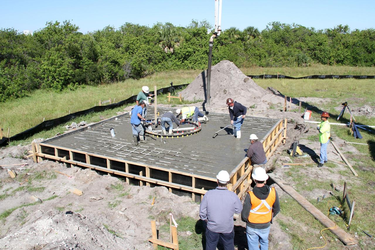 CAPE CANAVERAL, Fla. – At NASA’s Kennedy Space Center in Florida, workers pour and spread concrete at the base of the site of the Antenna Test Bed Array for the Ka-Band Objects Observation and Monitoring, Ka-BOOM system.     The construction site is near the former Vertical Processing Facility, which has been demolished. Workers are placing the pile foundations for the 40-foot-diameter dish antenna arrays and their associated utilities, and preparing the site for the operations command center facility. Photo credit: NASA/Ben Smegelski