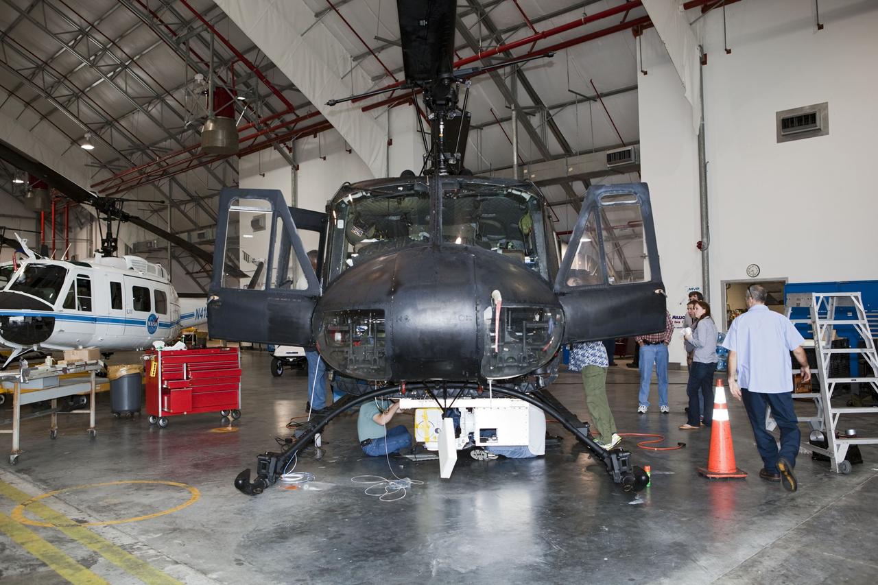 CAPE CANAVERAL, Fla. – Near the Shuttle Landing Facility at NASA's Kennedy Space Center in Florida, a space agency team installed and tested hazard avoidance instrumentation on a Huey helicopter. Led by the Johnson Space Center and supported by Jet Propulsion Laboratory and Langley Research Center, the Autonomous Landing Hazard Avoidance Technology, or ALHAT, laser system provides a planetary lander the ability to precisely land safely on a surface while detecting any dangerous obstacles such as rocks, holes and slopes. Just north of Kennedy's Shuttle Landing Facility runway, a rock- and crater-filled planetary scape has been built so engineers can test the ability to negotiate away from risks. Photo credit: NASA/Dmitri Gerondidakis