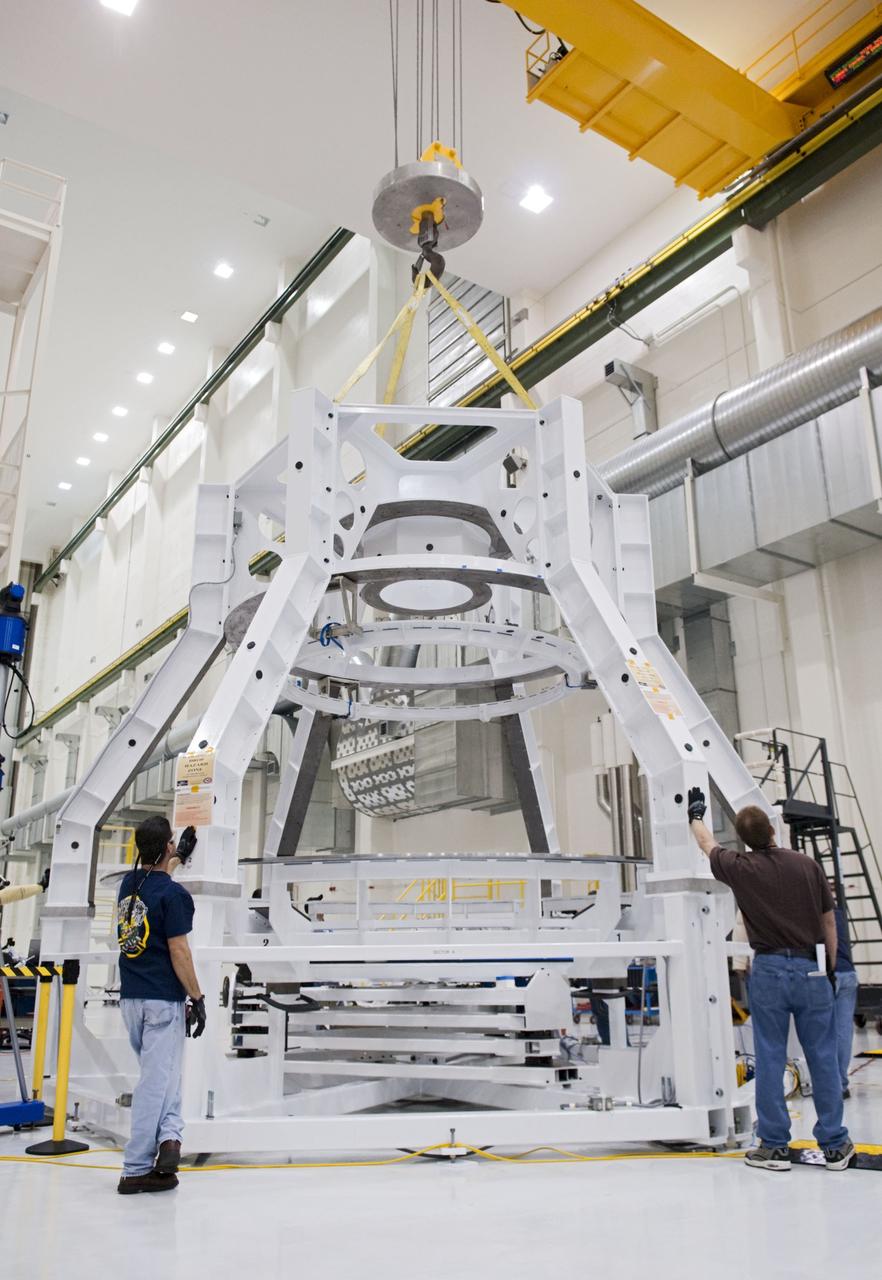 CAPE CANAVERAL, Fla. – Technicians prepare to lift a special fixture inside the high bay of the Operations & Checkout Building at NASA's Kennedy Space Center in Florida. The fixture is designed to enable precise pre-launch processing of the Orion spacecraft. An Orion capsule is being prepared to make a flight test in 2014 on a mission that will not carry any astronauts. Photo by Tim Jacobs