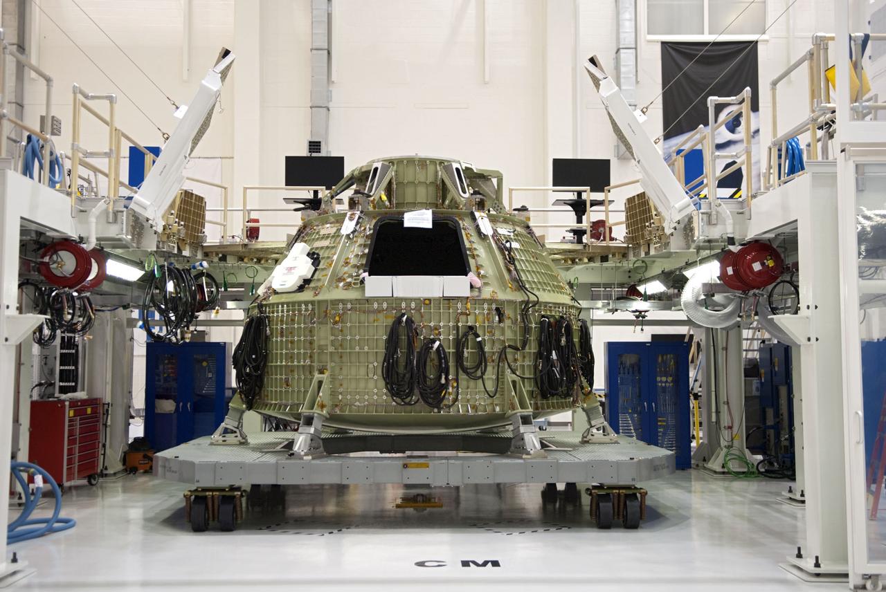 CAPE CANAVERAL, Fla. – Technicians prepare to fit a special fixture around an Orion capsule inside the high bay of the Operations & Checkout Building at NASA's Kennedy Space Center in Florida. The fixture is designed to enable precise pre-launch processing of the Orion spacecraft. An Orion capsule is being prepared to make a flight test in 2014 on a mission that will not carry any astronauts. Photo by Tim Jacobs
