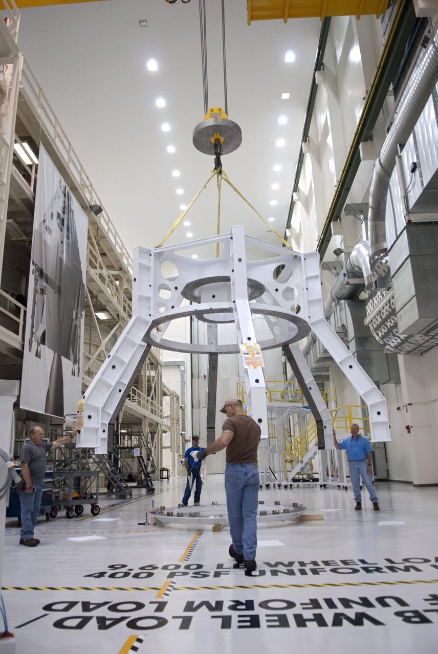 CAPE CANAVERAL, Fla. – Technicians lift a special fixture inside the high bay of the Operations & Checkout Building at NASA's Kennedy Space Center in Florida. The fixture is designed to enable precise pre-launch processing of the Orion spacecraft. An Orion capsule is being prepared to make a flight test in 2014 on a mission that will not carry any astronauts. Photo by Tim Jacobs