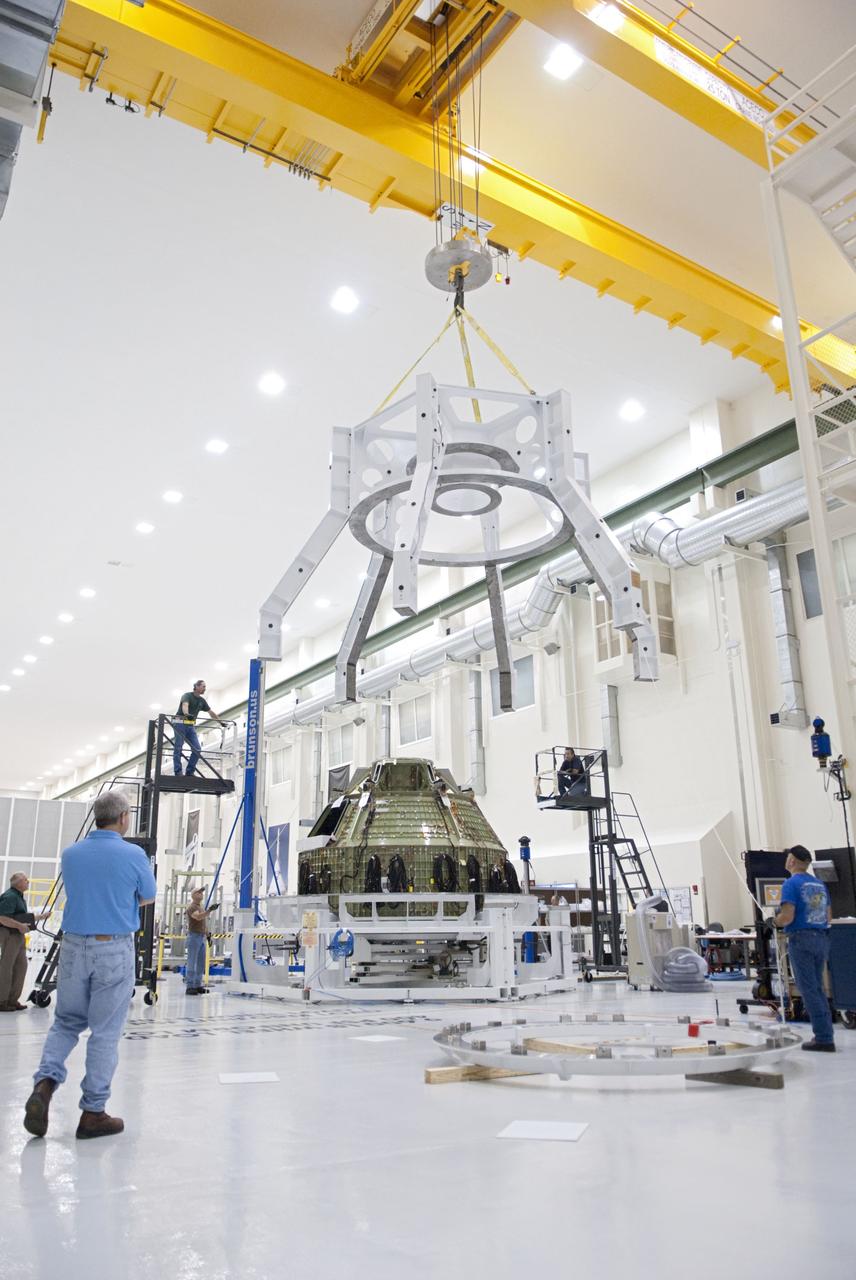 CAPE CANAVERAL, Fla. – Technicians lift a special fixture inside the high bay of the Operations & Checkout Building at NASA's Kennedy Space Center in Florida. The fixture is designed to enable precise pre-launch processing of the Orion spacecraft. An Orion capsule is being prepared to make a flight test in 2014 on a mission that will not carry any astronauts. Photo by Tim Jacobs