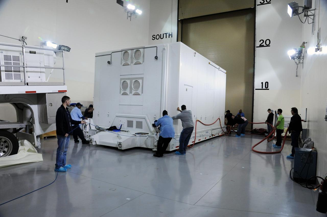VANDENBERG AFB, Calif.-- Technicians position the transport container with NASA's Landsat Data Continuity Mission, or LDCM, satellite at the prelaunch processing facility at Vandenberg Air Force Base, Calif.      The Landsat Data Continuity Mission LDCM is the future of Landsat satellites. It will continue to obtain valuable data and imagery to be used in agriculture, education, business, science, and government. The Landsat Program provides repetitive acquisition of high resolution multispectral data of the Earth's surface on a global basis. The data from the Landsat spacecraft constitute the longest record of the Earth's continental surfaces as seen from space. It is a record unmatched in quality, detail, coverage, and value. Launch is planned for Feb. 11, 2013. For more information, visit: http://www.nasa.gov/mission_pages/landsat/main/index.html Photo credit: NASA