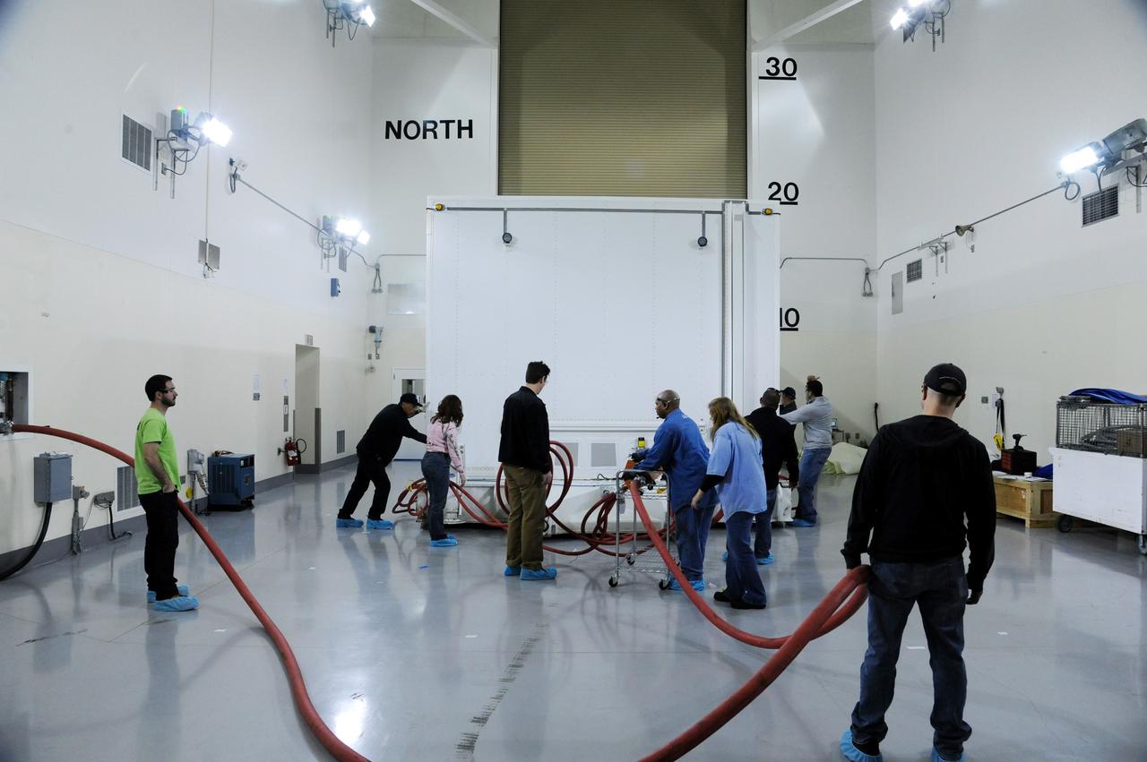 VANDENBERG AFB, Calif.-- Technicians position the transport container with NASA's Landsat Data Continuity Mission, or LDCM, satellite at the prelaunch processing facility at Vandenberg Air Force Base, Calif.      The Landsat Data Continuity Mission LDCM is the future of Landsat satellites. It will continue to obtain valuable data and imagery to be used in agriculture, education, business, science, and government. The Landsat Program provides repetitive acquisition of high resolution multispectral data of the Earth's surface on a global basis. The data from the Landsat spacecraft constitute the longest record of the Earth's continental surfaces as seen from space. It is a record unmatched in quality, detail, coverage, and value. Launch is planned for Feb. 11, 2013. For more information, visit: http://www.nasa.gov/mission_pages/landsat/main/index.html Photo credit: NASA