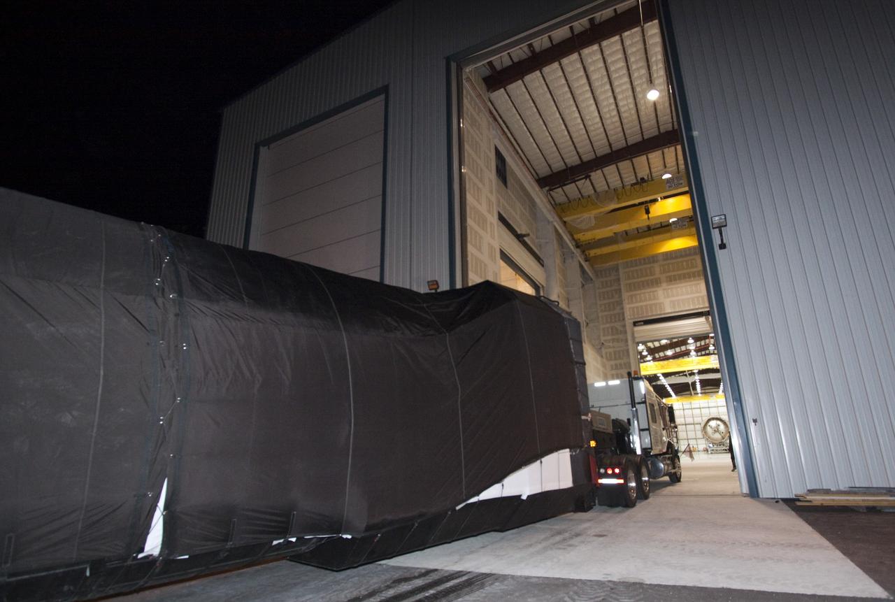 CAPE CANAVERAL, Fla. – The first stage of the Falcon 9 rocket arrives at the SpaceX Falcon Hangar at Launch Complex 40 on Cape Canaveral Air Force Station in Florida.    The two-stage rocket will launch the company's Dragon spacecraft on the upcoming SpaceX CRS-2 mission. The flight will be the second commercial resupply mission to the International Space Station by Space Exploration Technologies, or SpaceX. NASA has contracted for a total of 12 commercial resupply flights from SpaceX and eight from the Orbital Sciences Corp. Photo credit: NASA/Jim Grossmann