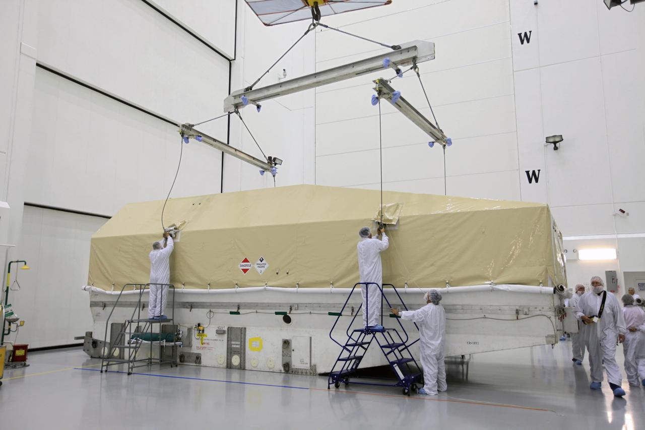 TITUSVILLE, Fla. - Technicians begin the process of removing the Tracking and Data Relay Satellite, TDRS-K, from the shipping container after arrival at the Astrotech payload processing facility in Titusville, Fla. near NASA’s Kennedy Space Center.      Launch of the TDRS-K on the Atlas V rocket is planned for January 29, 2013. The TDRS-K spacecraft is part of the next-generation series in the Tracking and Data Relay Satellite System, a constellation of space-based communication satellites providing tracking, telemetry, command and high-bandwidth data return services. For more information, visit http://www.nasa.gov/mission_pages/tdrs/index.html Photo credit: NASA/Kim Shiflett
