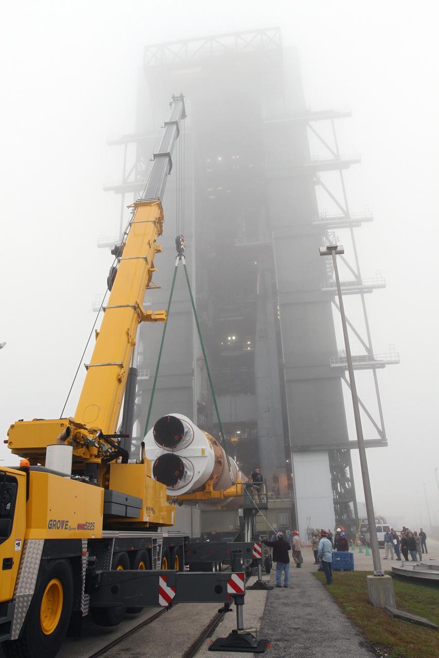 CAPE CANAVERAL, Fla. -- In the morning fog at Cape Canaveral Air Force Station's Space Launch Complex 41 in Florida, United Launch Alliance technicians support operations to erect the first stage of the Atlas V rocket that will carry the Tracking and Data Relay Satellite, TDRS-K, into orbit.      Launch of the TDRS-K on the Atlas V rocket is planned for January 29, 2013. The TDRS-K spacecraft is part of the next-generation series in the Tracking and Data Relay Satellite System, a constellation of space-based communication satellites providing tracking, telemetry, command and high-bandwidth data return services. For more information, visit http://www.nasa.gov/mission_pages/tdrs/index.html Photo credit: NASA/ Ben Smegelsky