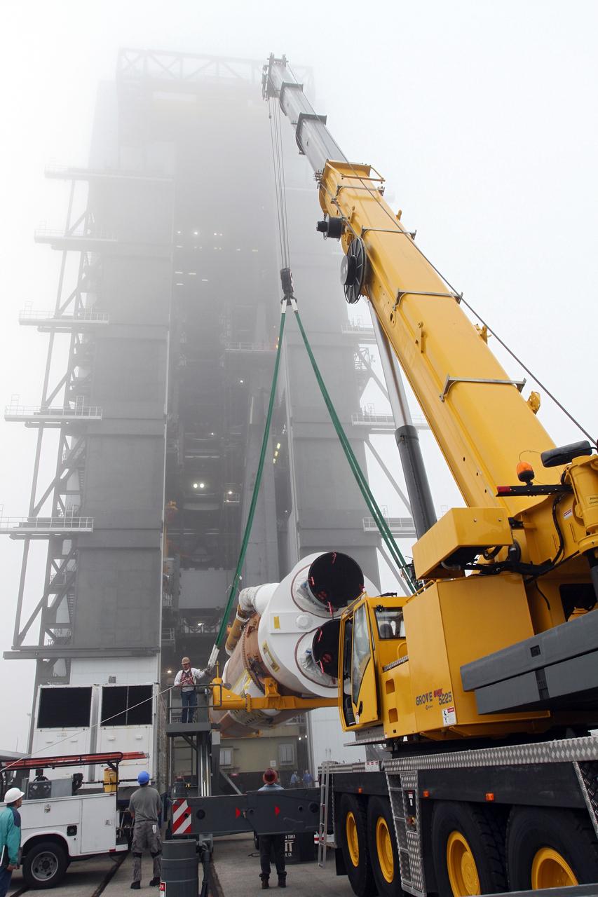 CAPE CANAVERAL, Fla. -- In the morning fog at Cape Canaveral Air Force Station's Space Launch Complex 41 in Florida, United Launch Alliance technicians support operations to erect the first stage of the Atlas V rocket that will carry the Tracking and Data Relay Satellite, TDRS-K, into orbit.      Launch of the TDRS-K on the Atlas V rocket is planned for January 29, 2013. The TDRS-K spacecraft is part of the next-generation series in the Tracking and Data Relay Satellite System, a constellation of space-based communication satellites providing tracking, telemetry, command and high-bandwidth data return services. For more information, visit http://www.nasa.gov/mission_pages/tdrs/index.html Photo credit: NASA/ Ben Smegelsky