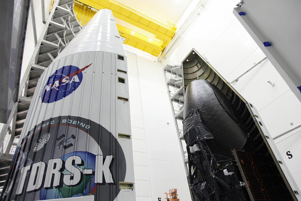 TITUSVILLE, Fla. – Technicians move one half of the payload fairing into place over NASA's Tracking and Data Relay Satellite, TDRS-K, inside the Astrotech payload processing facility in Titusville, Fla., near NASA’s Kennedy Space Center. Launch of the TDRS-K on a United Launch Alliance Atlas V rocket is planned for January 29, 2013. The TDRS-K spacecraft is part of the next-generation series in the Tracking and Data Relay Satellite System, a constellation of space-based communication satellites providing tracking, telemetry, command and high-bandwidth data return services. Photo credit: NASA/Frankie Martin