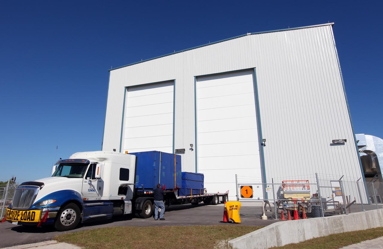 CAPE CANAVERAL, Fla. – A truck arrives at the processing hangar used by Space Exploration Technologies, or SpaceX, at Cape Canaveral Air Force Station, Fla. The truck is carrying solar array fairings to be installed on the Dragon spacecraft undergoing launch preparations inside the hangar. The spacecraft will launch on the upcoming SpaceX CRS-2 mission. The flight will be the second commercial resupply mission to the International Space Station by Space Exploration Technologies, or SpaceX. NASA has contracted for a total of 12 commercial resupply flights from SpaceX and eight from the Orbital Sciences Corp. Photo credit: NASA/Kim Shiflett