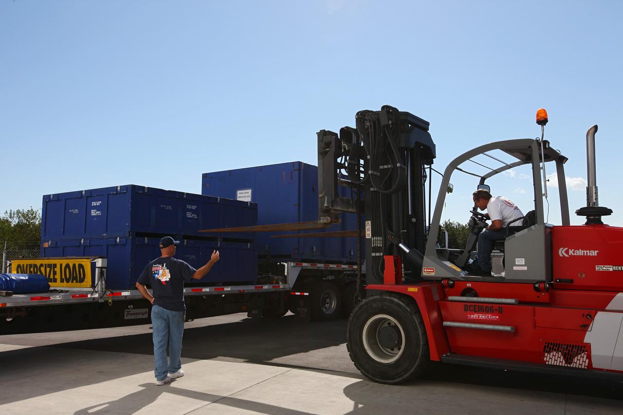 CAPE CANAVERAL, Fla. – Workers lift containers from a truck at the processing hangar used by Space Exploration Technologies, or SpaceX, at Cape Canaveral Air Force Station, Fla. The truck is carrying solar array fairings to be installed on the Dragon spacecraft undergoing launch preparations inside the hangar. The spacecraft will launch on the upcoming SpaceX CRS-2 mission. The flight will be the second commercial resupply mission to the International Space Station by SpaceX. NASA has contracted for a total of 12 commercial resupply flights from SpaceX and eight from the Orbital Sciences Corp. Photo credit: NASA/Kim Shiflett