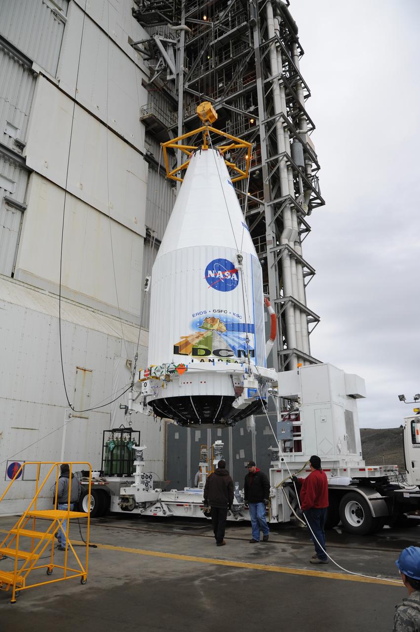 VANDENBERG AIR FORCE BASE, Calif. ---The payload faring containing the Landsat Data Continuity Mission LDCM spacecraft is lifted from a transporter at Vandenberg Air Force Base's Space Launch Complex-3E where it will be hoisted atop a United Launch Alliance Atlas V for launch.      LDCM is the eighth satellite in the Landsat Program series of Earth-observing missions jointly managed by NASA and the U.S. Geological Survey. LDCM will continue the program’s critical role in monitoring, understanding and managing the resources needed for human sustainment such as food, water and forests. Photo credit: NASA/VAFB