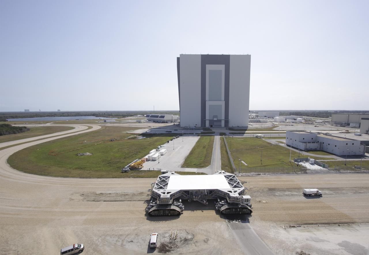 CAPE CANAVERAL, Fla. – At NASA’s Kennedy Space Center in Florida, the crawler-transporter 2, or CT-2, is on its way from the Vehicle Assembly Building to the Park Site west of the building. The transporter has new brakes and mufflers and a recently-painted white roof deck. Out in front is a truck spraying water to control the dust on the crawlerway. The Ground Systems Development and Operations Program office at Kennedy is overseeing the upgrades to CT-2 so that it can carry NASA’s Space Launch System heavy-lift rocket, which is under design, and new Orion spacecraft to the launch pad. The crawler-transporters were used to carry the mobile launcher platform and space shuttle to Launch Complex 39 for space shuttle launches for 30 years. Photo credit: NASA/Jim Grossmann