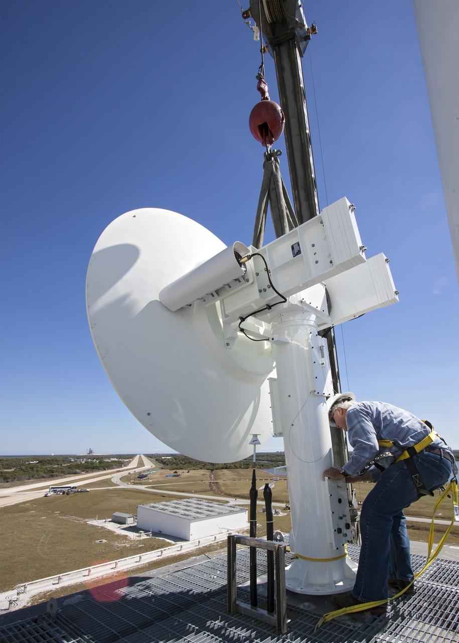 CAPE CANAVERAL, Fla. – With the help of a crane, a worker helps guide a parabolic telemetry antenna and tracker camera to the roof of the Launch Control Center, or LCC, in Launch Complex 39 at NASA's Kennedy Space Center in Florida. This antenna and camera system is the first of three that will be installed on the LCC roof for the Radio Frequency and Telemetry Station RFTS, which will be used to monitor radio frequency communications from a launch vehicle at Launch Pad 39A or B as well as provide radio frequency relay for a launch vehicle in the Vehicle Assembly Building. The RFTS replaces the shuttle-era communications and tracking labs at Kennedy. The modern RFTS checkout station is designed to primarily support NASA's Space Launch System, or SLS, and Orion spacecraft, but can support multi-user radio frequency tests as the space center transitions to support a variety of rockets and spacecraft.      For more information on the modernization efforts at Kennedy, visit the Ground Systems Development and Operations, or GSDO, website at http://go.nasa.gov/groundsystems. Photo credit: NASA/Jim Grossmann