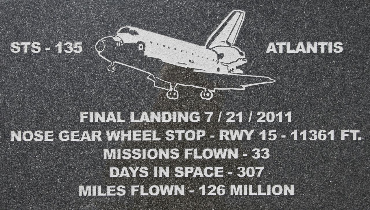 CAPE CANAVERAL, Fla. – At Kennedy Space Center's Shuttle Landing Facility, a granite plaque marks the spot where space shuttle Atlantis' nose gear came to a stop at the conclusion of STS-135, the final flight of the Space Shuttle Program.     Permanent reminders indicate where on the runway the orbiters Discovery, Endeavour and Atlantis stopped rolling as each finished its last mission in 2011. In addition to the granite markers, which are installed alongside the runway, there are etchings in the grooved concrete along the runway's centerline to mark each wheelstop. The etchings and markers were created and installed by local artist Chad Stout of C Spray Glass Blasting in Cocoa, Fla. Photo credit: NASA/Tim Jacobs