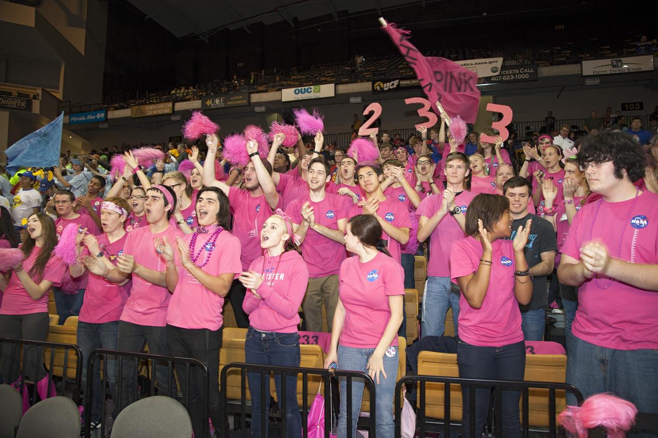 ORLANDO, Fla. – The Pink Team cheers as their robot competes in the University of Central Florida Arena as part of the FIRST Robotics Competition's 2013 Orlando Regional. The student-built robots were required to throw discs into boxes or make climbs to score points. Photo credit: NASA/Frankie Martin