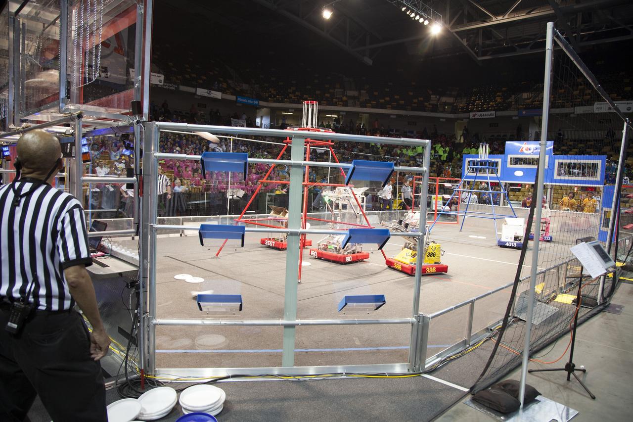 ORLANDO, Fla. – Robots built and operated by teams of high school students compete in the University of Central Florida Arena as part of the FIRST Robotics Competition's 2013 Orlando Regional. The robots were required to throw discs into boxes or make climbs to score points. Photo credit: NASA/Frankie Martin