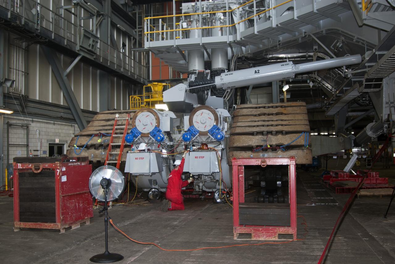 CAPE CANAVERAL, Fla. -- Technicians in the Vehicle Assembly Building at NASA’s Kennedy Space Center in Florida, prepare to jack crawler-transporter 2, or CT-2, four feet off the floor to facilitate removal of the roller bearing assemblies. After inspections, new assemblies will be installed.      The Ground Systems Development and Operations Program office at Kennedy is overseeing the upgrades to CT-2 so that it can carry NASA’s Space Launch System heavy-lift rocket and new Orion spacecraft to the launch pad. For more than 45 years the crawler-transporters were used to transport the mobile launcher platform and the Apollo-Saturn V rockets and, later, space shuttles to Launch Pads 39A and B. Photo credit: NASA/Charisse Nahser