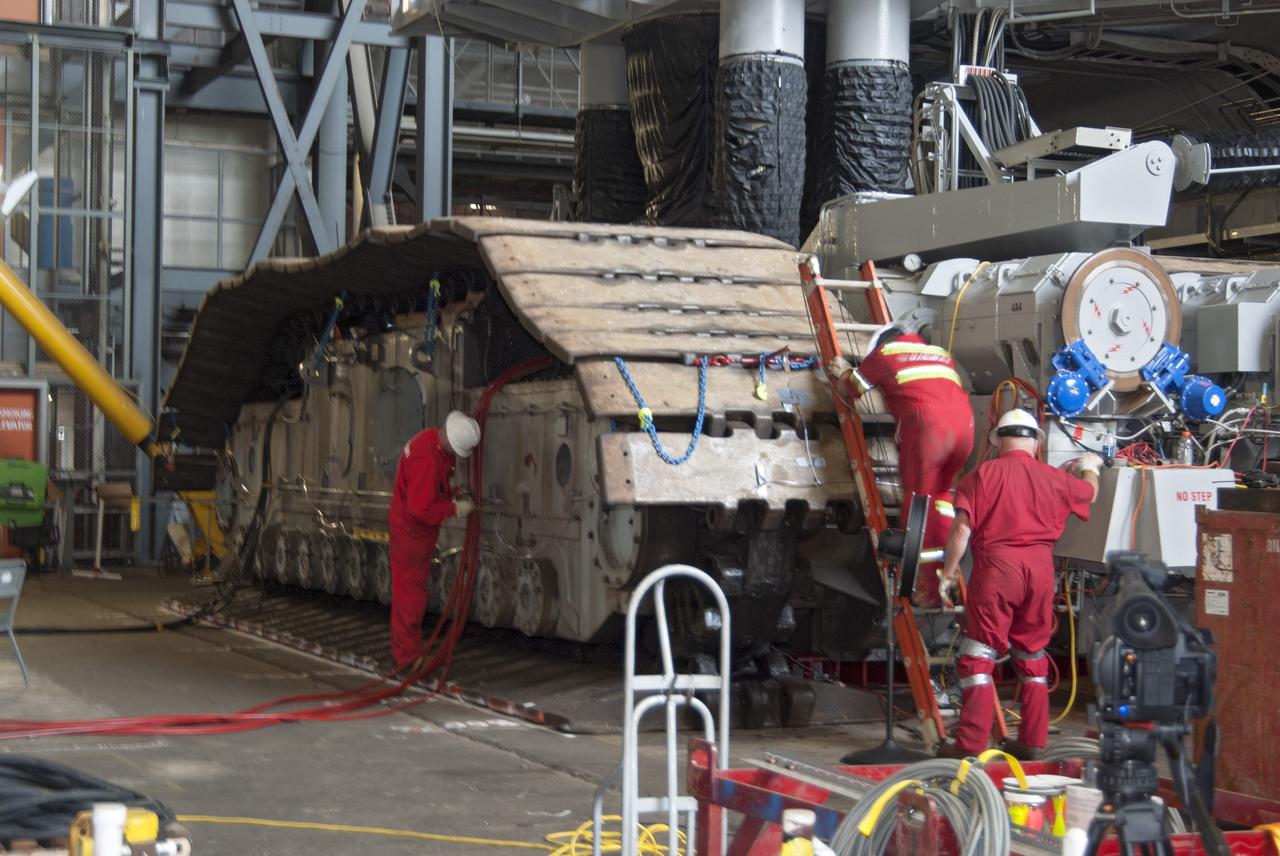 CAPE CANAVERAL, Fla. -- Technicians in the Vehicle Assembly Building at NASA’s Kennedy Space Center in Florida, prepare to jack crawler-transporter 2, or CT-2, four feet off the floor to facilitate removal of the roller bearing assemblies. After inspections, new assemblies will be installed.      The Ground Systems Development and Operations Program office at Kennedy is overseeing the upgrades to CT-2 so that it can carry NASA’s Space Launch System heavy-lift rocket and new Orion spacecraft to the launch pad. For more than 45 years the crawler-transporters were used to transport the mobile launcher platform and the Apollo-Saturn V rockets and, later, space shuttles to Launch Pads 39A and B. Photo credit: NASA/Charisse Nahser