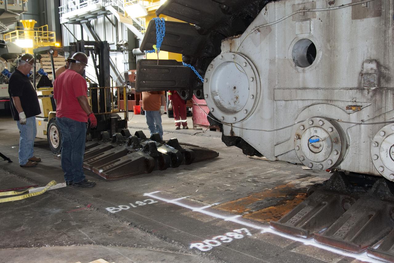 CAPE CANAVERAL, Fla. -- Technicians in the Vehicle Assembly Building at NASA’s Kennedy Space Center in Florida, are removing track shoes from crawler-transporter 2, or CT-2, prior to jacking it four feet off the floor to facilitate removal of the roller bearing assemblies. After inspections, new assemblies will be installed.      The Ground Systems Development and Operations Program office at Kennedy is overseeing the upgrades to CT-2 so that it can carry NASA’s Space Launch System heavy-lift rocket and new Orion spacecraft to the launch pad. For more than 45 years the crawler-transporters were used to transport the mobile launcher platform and the Apollo-Saturn V rockets and, later, space shuttles to Launch Pads 39A and B. Photo credit: NASA/Charisse Nahser
