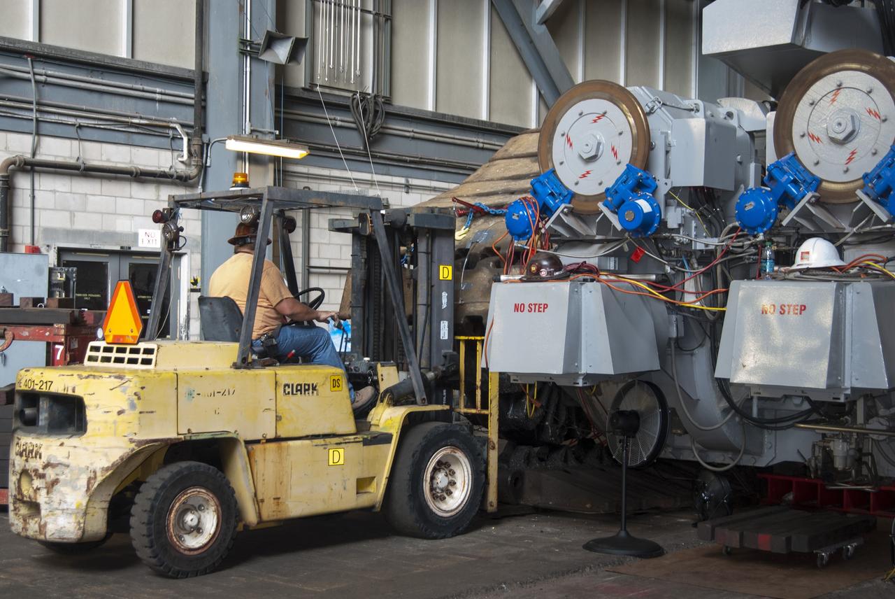 CAPE CANAVERAL, Fla. -- In the Vehicle Assembly Building at NASA’s Kennedy Space Center in Florida, a technician uses a fork lift to remove track shoes from crawler-transporter 2, or CT-2, prior to jacking it four feet off the floor to facilitate removal of the roller bearing assemblies. After inspections, new assemblies will be installed.      The Ground Systems Development and Operations Program office at Kennedy is overseeing the upgrades to CT-2 so that it can carry NASA’s Space Launch System heavy-lift rocket and new Orion spacecraft to the launch pad. For more than 45 years the crawler-transporters were used to transport the mobile launcher platform and the Apollo-Saturn V rockets and, later, space shuttles to Launch Pads 39A and B. Photo credit: NASA/Charisse Nahser
