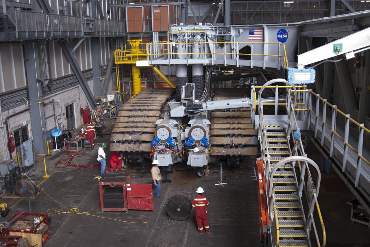 CAPE CANAVERAL, Fla. -- Technicians in the Vehicle Assembly Building at NASA’s Kennedy Space Center in Florida, are removing track shoes from crawler-transporter 2, or CT-2, prior to jacking it four feet off  the floor to facilitate removal of the roller bearing assemblies. After inspections, new assemblies will be installed.      The Ground Systems Development and Operations Program office at Kennedy is overseeing the upgrades to CT-2 so that it can carry NASA’s Space Launch System heavy-lift rocket and new Orion spacecraft to the launch pad. For more than 45 years the crawler-transporters were used to transport the mobile launcher platform and the Apollo-Saturn V rockets and, later, space shuttles to Launch Pads 39A and B. Photo credit: NASA/Charisse Nahser