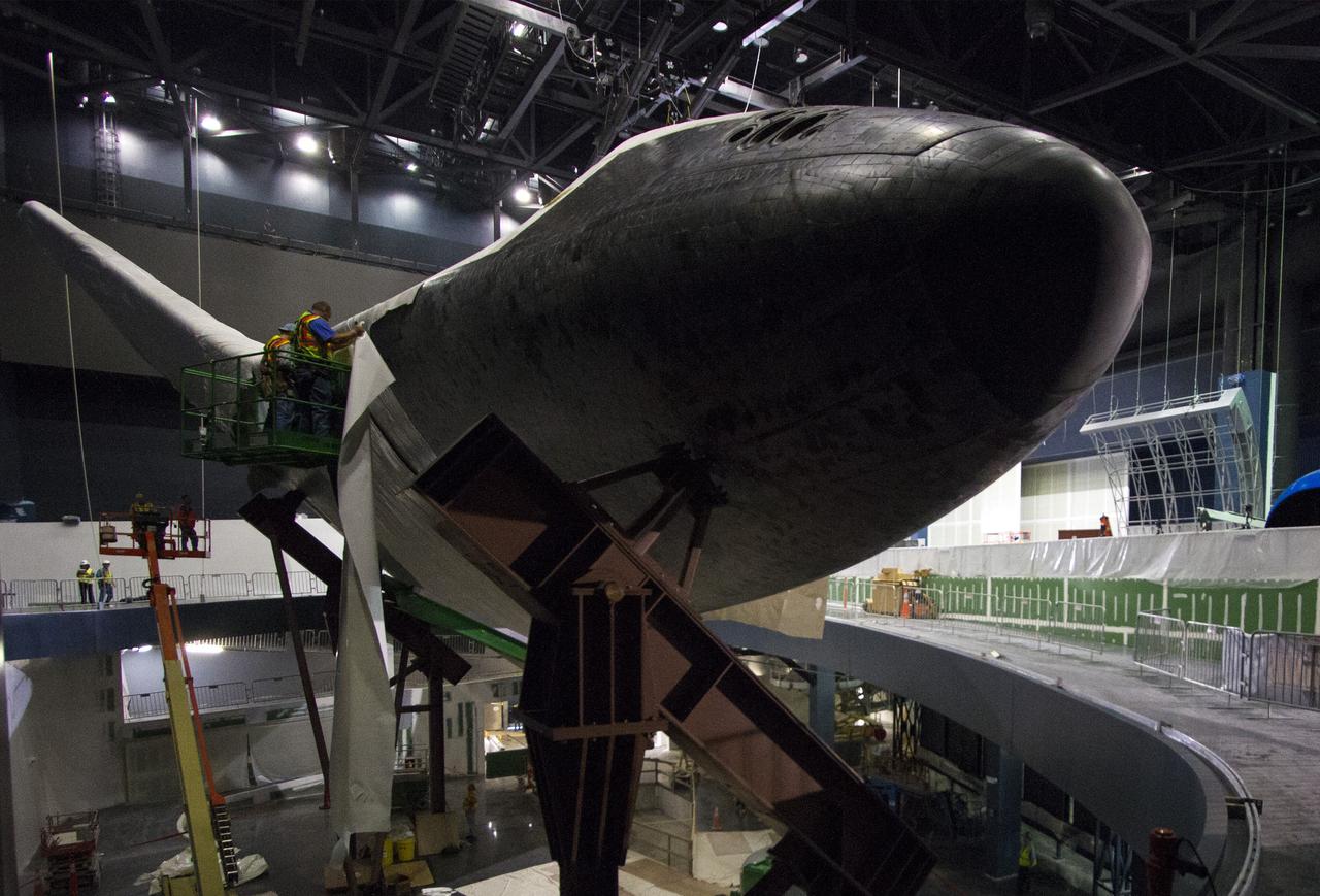 CAPE CANAVERAL, Fla. -- At the Kennedy Space Center Visitor Complex in Florida, construction crews are removing 16,000 square feet of plastic shrink-wrap from the space shuttle Atlantis. The spacecraft was enclosed in the plastic shrink-wrap since November of last year to protect the artifact from dust and debris during construction of the 90,000-square-foot facility. Last November, the space shuttle Atlantis made its historic final journey to its new home, traveling 10 miles from the Kennedy Space Center's Vehicle Assembly Building to the spaceport's visitor complex. The new $100 million "Space Shuttle Atlantis" facility will include interactive exhibits that tell the story of the 30-year Space Shuttle Program and highlights the future of space exploration. The "Space Shuttle Atlantis" exhibit scheduled to open June 29, 2013.Photo credit: NASA/Cory Huston