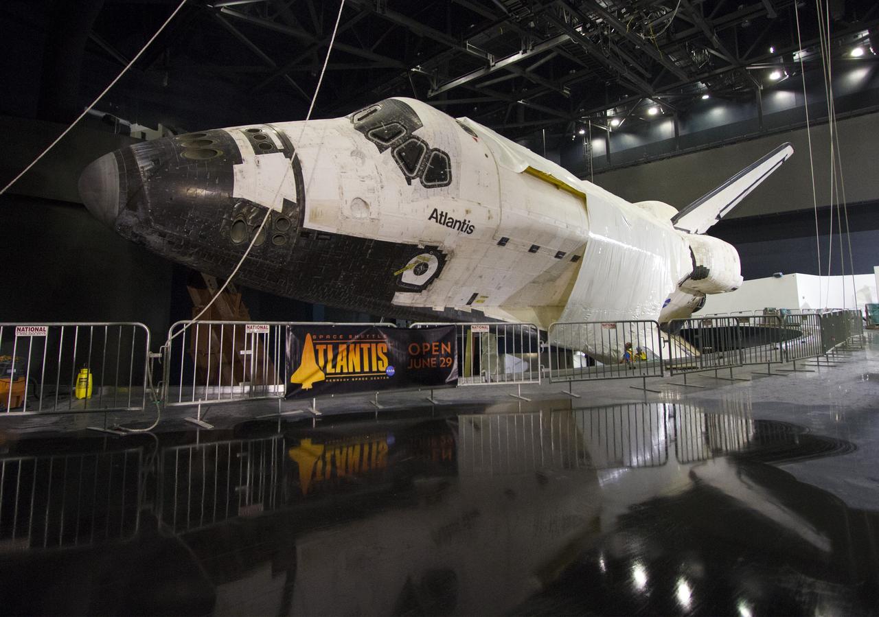 CAPE CANAVERAL, Fla. -- At the Kennedy Space Center Visitor Complex in Florida, construction crews are removing 16,000 square feet of plastic shrink-wrap from the space shuttle Atlantis. The spacecraft was enclosed in the plastic shrink-wrap since November of last year to protect the artifact from dust and debris during construction of the 90,000-square-foot facility. Last November, the space shuttle Atlantis made its historic final journey to its new home, traveling 10 miles from the Kennedy Space Center's Vehicle Assembly Building to the spaceport's visitor complex. The new $100 million "Space Shuttle Atlantis" facility will include interactive exhibits that tell the story of the 30-year Space Shuttle Program and highlights the future of space exploration. The "Space Shuttle Atlantis" exhibit scheduled to open June 29, 2013.Photo credit: NASA/Cory Huston