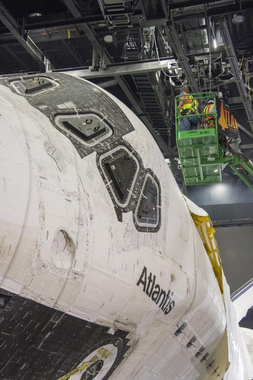 CAPE CANAVERAL, Fla. -- At the Kennedy Space Center Visitor Complex in Florida, construction crews are removing 16,000 square feet of plastic shrink-wrap from the space shuttle Atlantis. The spacecraft was enclosed in the plastic shrink-wrap since November of last year to protect the artifact from dust and debris during construction of the 90,000-square-foot facility. Last November, the space shuttle Atlantis made its historic final journey to its new home, traveling 10 miles from the Kennedy Space Center's Vehicle Assembly Building to the spaceport's visitor complex. The new $100 million "Space Shuttle Atlantis" facility will include interactive exhibits that tell the story of the 30-year Space Shuttle Program and highlights the future of space exploration. The "Space Shuttle Atlantis" exhibit scheduled to open June 29, 2013.Photo credit: NASA/Cory Huston