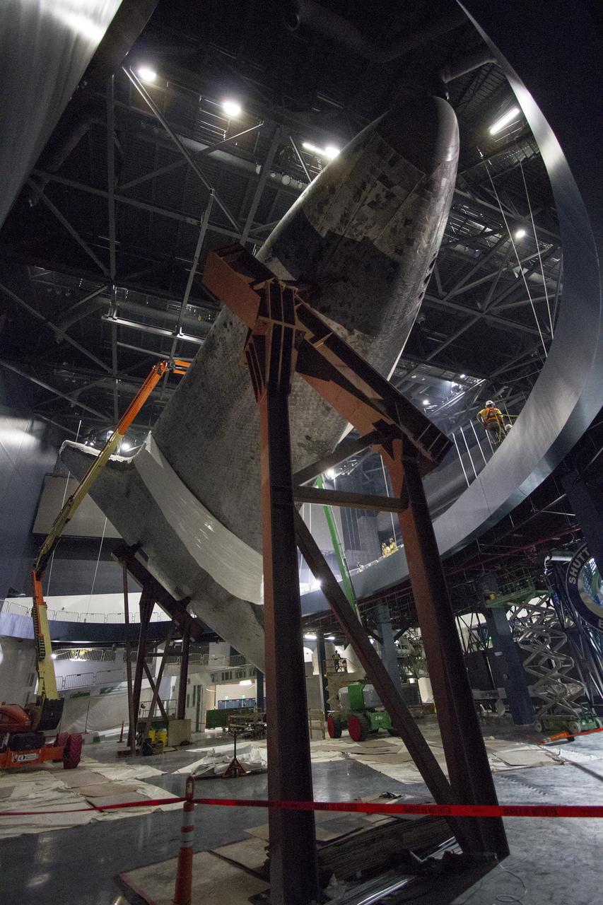 CAPE CANAVERAL, Fla. -- At the Kennedy Space Center Visitor Complex in Florida, construction crews are removing 16,000 square feet of plastic shrink-wrap from the space shuttle Atlantis. The spacecraft was enclosed in the plastic shrink-wrap since November of last year to protect the artifact from dust and debris during construction of the 90,000-square-foot facility. Last November, the space shuttle Atlantis made its historic final journey to its new home, traveling 10 miles from the Kennedy Space Center's Vehicle Assembly Building to the spaceport's visitor complex. The new $100 million "Space Shuttle Atlantis" facility will include interactive exhibits that tell the story of the 30-year Space Shuttle Program and highlights the future of space exploration. The "Space Shuttle Atlantis" exhibit scheduled to open June 29, 2013.Photo credit: NASA/Cory Huston