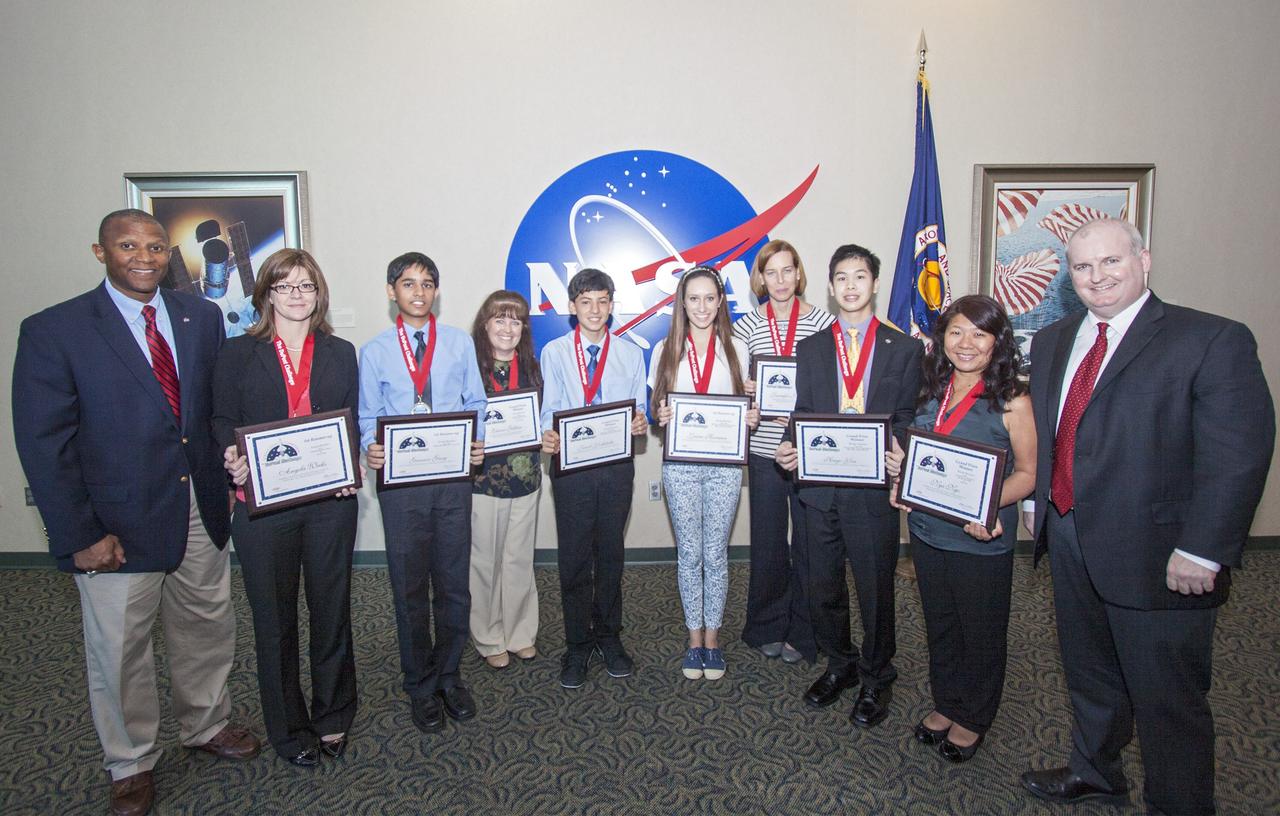 CAPE CANAVERAL, Fla. - The winning students and their teachers of the 2013 DuPont Challenge Science Essay Competition show off their awards after a ceremony at the Kennedy Space Center Visitor Complex in Florida. From left are, Kelvin Manning, the center's associate deputy director sponsoring teacher Angela Weeks and Junior Division first runner-up Gaurav Garg of Beckendorff Junior High in Katy, Texas sponsoring teacher Elaine Gillum and Senior Division grand prize winner Jacob Yoshitake of Marshall Middle School in San Diego, Calif. Senior Division first runner-up Laura Herman and sponsoring teacher Jennifer Gordinier of Pine Crest School in Fort Lauderdale, Fla. and Senior Division grand prize awardee Hugo Yen and sponsoring teacher Nga Ngo of Troy High in Fullerton, Calif. The challenge, now in its 27th year, reaches out to students from grades seven through 12 from all 50 states and Canada. More than 200,000 students entered the competition. The DuPont Challenge aims to inspire students to excel and achieve in scientific writing and pursue careers in science, technology, engineering and mathematics STEM. The challenge honors space shuttle Challenger's STS-51L crew members who gave their lives while furthering the cause of exploration and discovery. For more information on the challenge, go to http://thechallenge.dupont.com/sponsors/nasa.php.