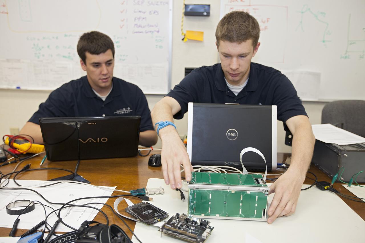 CAPE CANAVERAL, Fla. – Students from California Polytechnic Institute, or CalPoly, perform integration tests on a cubesat called PolySat they will fly on a suborbital mission in the summer. The satellite will work inside a small rocket to measure vibration and other data during launch. NASA engineers are acting as mentors for the project and some of the space agency's labs at Kennedy Space Center, including this one inside the Operations and Checkout Building, are being used by the teams. Photo credit: NASA/Kim Shiflett