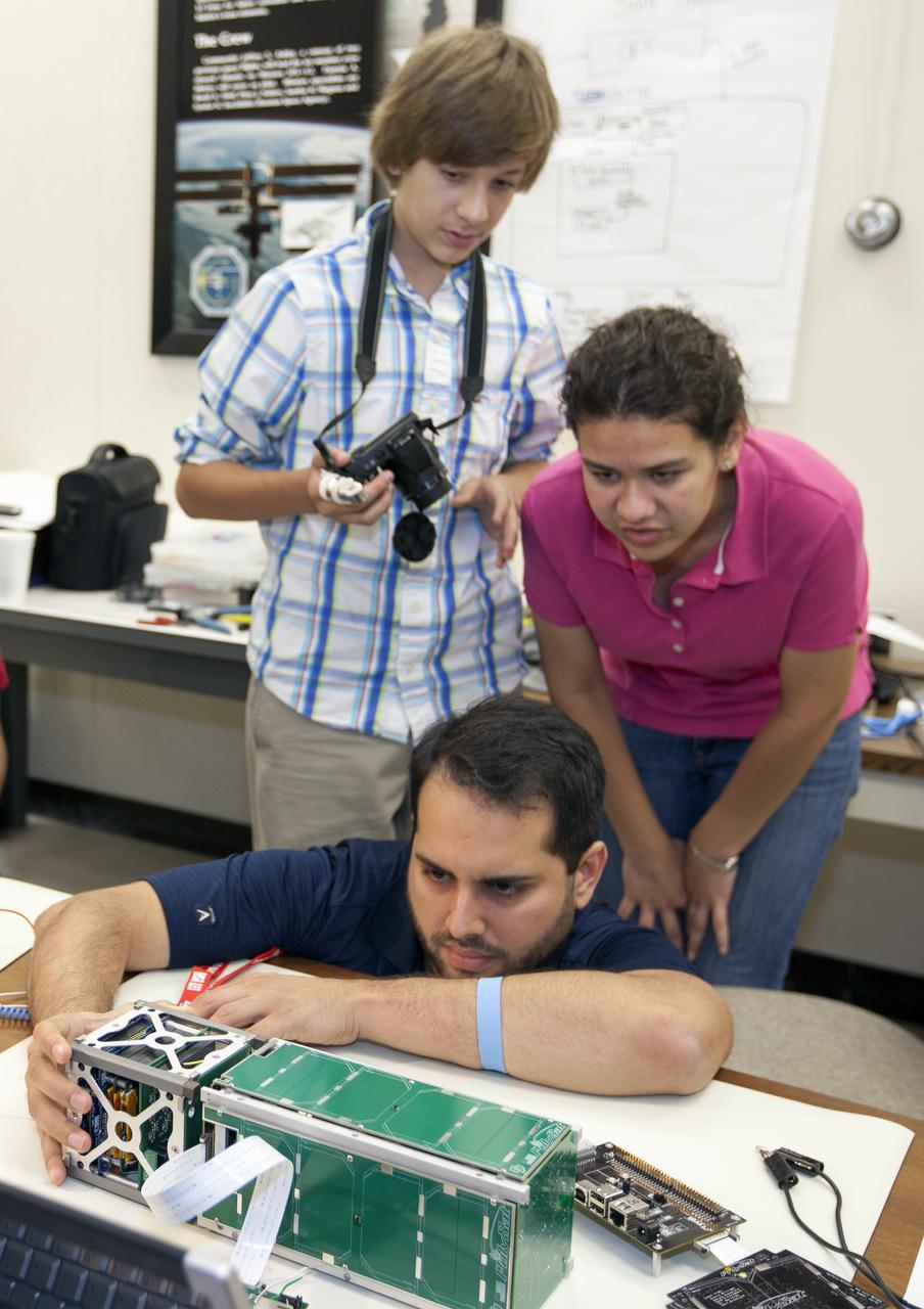CAPE CANAVERAL, Fla. – Students from California Polytechnic Institute, or CalPoly, and Merritt Island High School in Florida perform integration tests on a pair of cubesats they will fly on a suborbital mission in the summer. A team from each school built a satellite and the two will work together inside a small rocket to measure vibration and other data during launch. NASA engineers are acting as mentors for the project and some of the space agency's labs at Kennedy Space Center, including this one inside the Operations and Checkout Building, are being used by the teams. Photo credit: NASA/Kim Shiflett