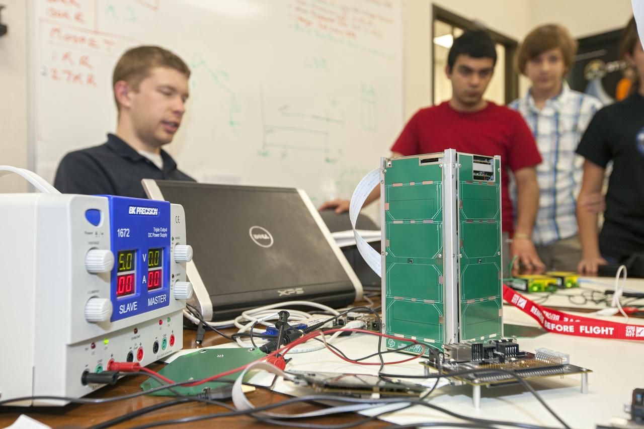 CAPE CANAVERAL, Fla. – Students from California Polytechnic Institute, or CalPoly, and Merritt Island High School in Florida perform integration tests on a pair of cubesats they will fly on a suborbital mission in the summer. A team from each school built a satellite and the two will work together inside a small rocket to measure vibration and other data during launch. NASA engineers are acting as mentors for the project and some of the space agency's labs at Kennedy Space Center, including this one inside the Operations and Checkout Building, are being used by the teams. Photo credit: NASA/Kim Shiflett