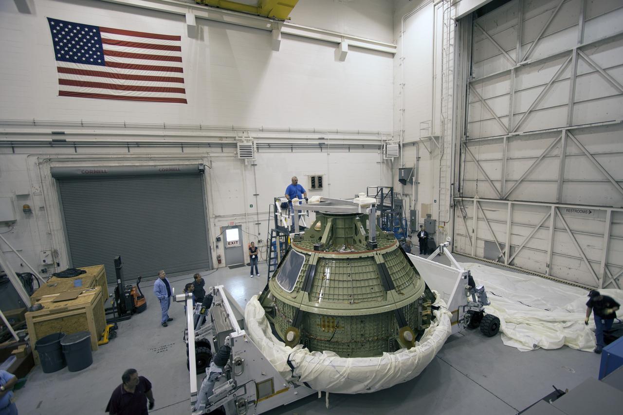CAPE CANAVERAL, Fla. -- At NASA’s Kennedy Space Center in Florida,  Lockheed Martin crews uncover the Orion ground test vehicle in the Launch Equipment Test Facility, or LETF. The GTA was moved from the Operations and Checkout Facility to the LETF for a series of pyrotechnic bolt tests. The GTA is being used for path finding operations in the O&C, including simulated manufacturing and assembly procedures.    Launching atop NASA's heavy-lift Space Launch System SLS, which also is under development, the Orion Multi-Purpose Crew Vehicle MPCV will serve as the exploration vehicle that will carry astronaut crews beyond low Earth orbit. It also will provide emergency abort capabilities, sustain the crew during space travel and provide safe re-entry from deep space return velocities. For more information, visit www.nasa.gov/orion. Photo credit: Jim Grossman