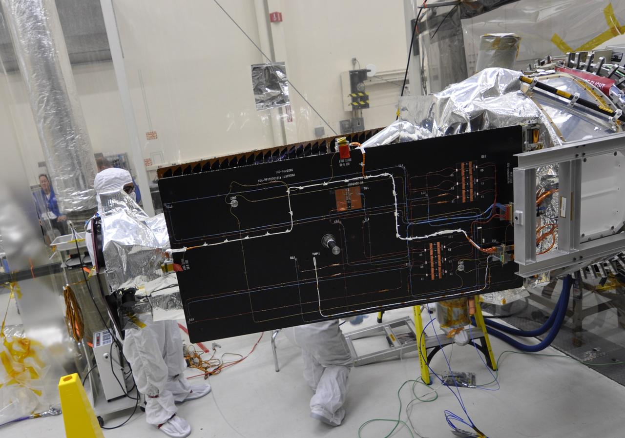 VANDENBERG AFB, Calif. – Engineers unwrap NASA's IRIS spacecraft after its connection to the nose of an Orbital Sciences Pegasus XL rocket that will lift the solar observatory into orbit in June. The work is taking place in a hangar at Vandenberg Air Force Base where IRIS, short for Interface Region Imaging Spectrograph, is being prepared for launch on a Pegasus XL rocket. Scheduled for launch from Vandenberg June 26, IRIS will open a new window of discovery by tracing the flow of energy and plasma through the chromospheres and transition region into the sun’s corona using spectrometry and imaging. IRIS fills a crucial gap in our ability to advance studies of the sun-to-Earth connection by tracing the flow of energy and plasma through the foundation of the corona and the region around the sun known as the heliosphere. Photo credit: NASA/Randy Beaudoin