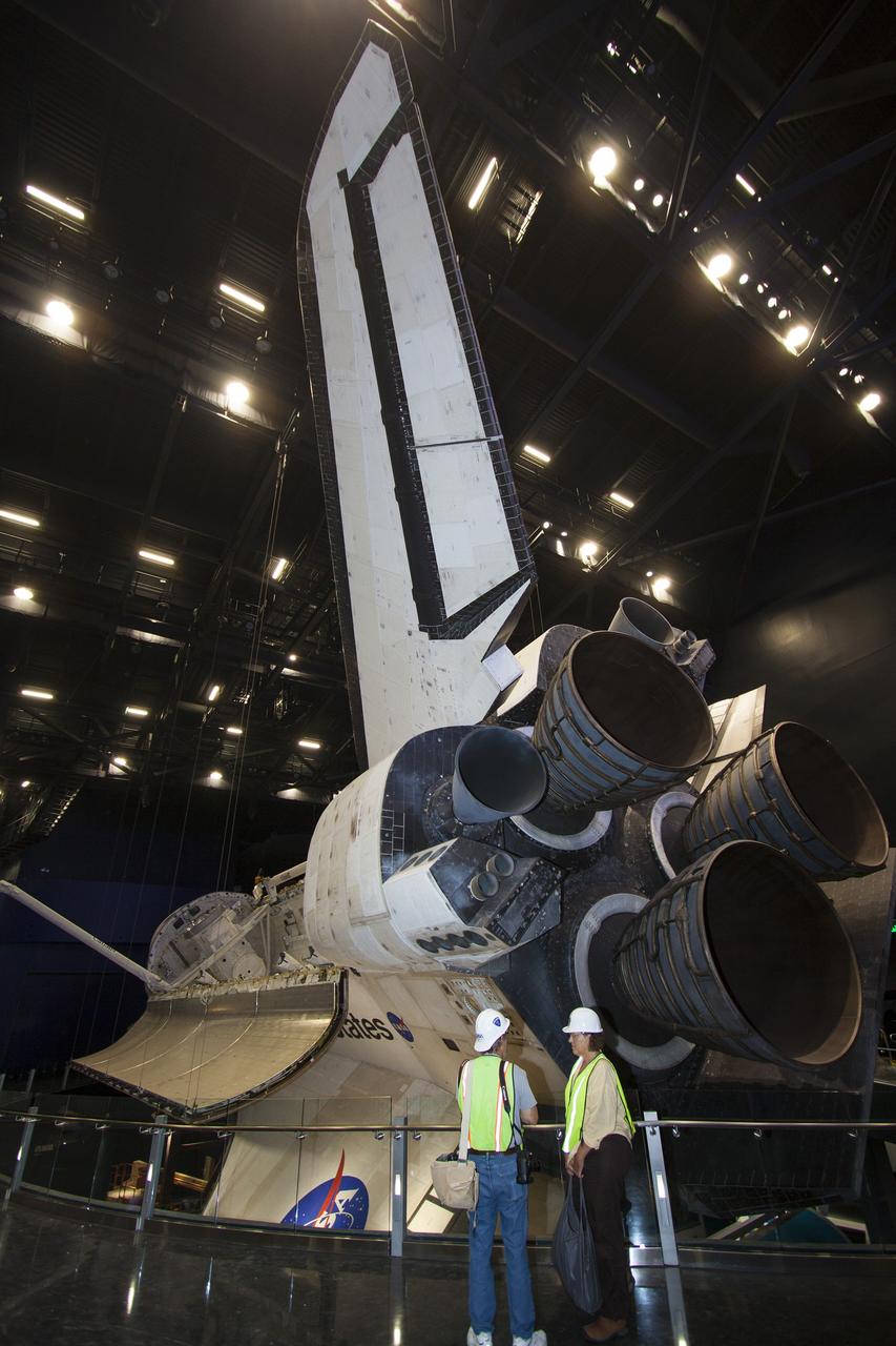 CAPE CANAVERAL, Fla. – At the Kennedy Space Center Visitor Complex in Florida, members of the media tour the new “Space Shuttle Atlantis” exhibit, a 90,000-square-foot facility, scheduled to open June 29, 2013. Space shuttle Atlantis’ payload bay doors are open and the orbiter has been tilted at a 43.21 angle to the portside and supported by special jacks to elevate it 26 feet from the ground. The robotic arm has been installed in the payload bay.    The new $100 million facility will include interactive exhibits that tell the story of the 30-year Space Shuttle Program and highlight the future of space exploration. Visitors to the exhibit will get an up close look at Atlantis with its payload bay doors open, similar to how it looked in space. Photo credit: NASA/Jim Grossmann