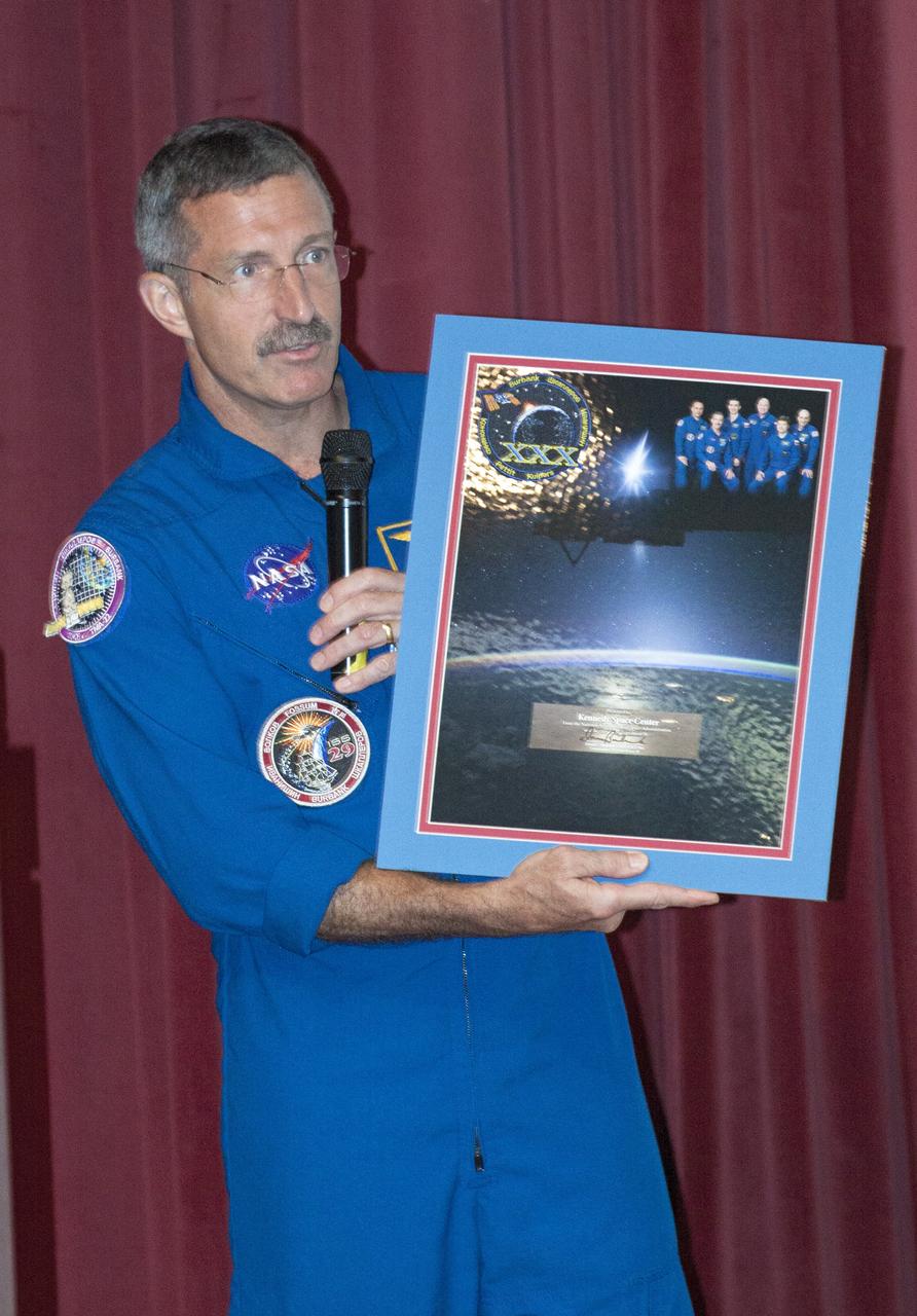 CAPE CANAVERAL, Fla. -- Expedition 30 Commander Dan Burbank presents a commemorative collage of photographs from his mission to Kennedy Space Center Director Bob Cabana for the employees of NASA's Florida spaceport for their support of the International Space Station.      Burbank spent 165 days aboard the station during expeditions 29 and 30. For more information on the space station, visit http://www.nasa.gov/mission_pages/station/expeditions/index.html  Photo credit: NASA/Kim Shiflett & Gianni Woods
