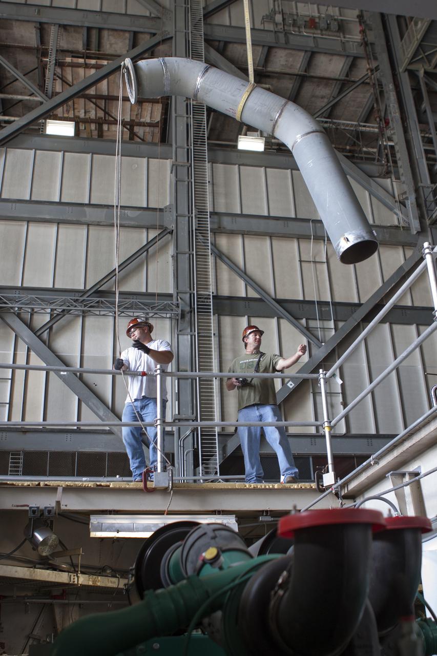 CAPE CANAVERAL, Fla. – Inside the Vehicle Assembly Building at NASA’s Kennedy Space Center in Florida, technicians prepare piping for a new exhaust system for installation in crawler-transporter 1, or CT-1. Work continues in high bay 3 to upgrade CT-1 as part of its general maintenance. CT-1 could be available to carry commercial launch vehicles to the launch pad. The crawler-transporters were used to carry the mobile launcher platform and space shuttle to Launch Complex 39 for space shuttle launches for 30 years. Photo credit: NASA/Jim Grossmann