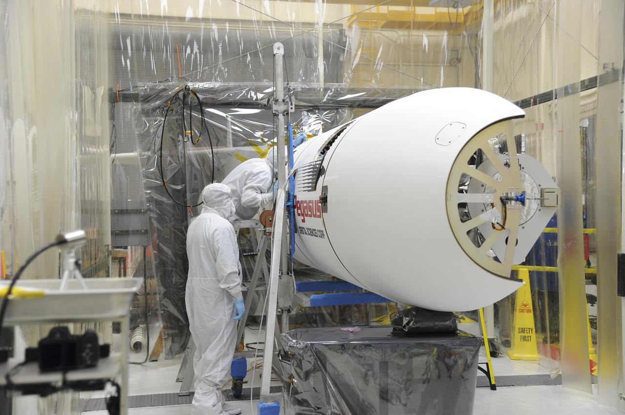 Orbital Sciences engineers connect the payload fairing over NASA's IRIS spacecraft. The fairing connects to the nose of the Orbital Sciences Pegasus XL rocket that will lift the solar observatory into orbit in June. The work is taking place in a hangar at Vandenberg Air Force Base where IRIS, short for Interface Region Imaging Spectrograph, is being prepared for launch on a Pegasus XL rocket. Scheduled for launch from Vandenberg June 26, IRIS will open a new window of discovery by tracing the flow of energy and plasma through the chromospheres and transition region into the sun’s corona using spectrometry and imaging. IRIS fills a crucial gap in our ability to advance studies of the sun-to-Earth connection by tracing the flow of energy and plasma through the foundation of the corona and the region around the sun known as the heliosphere. Photo credit: NASA/Tony Vauclin