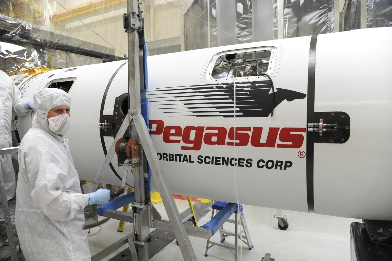VANDENBERG AFB - Orbital Sciences engineers connect the payload fairing over NASA's IRIS spacecraft. The fairing connects to the nose of the Orbital Sciences Pegasus XL rocket that will lift the solar observatory into orbit in June. The work is taking place in a hangar at Vandenberg Air Force Base where IRIS, short for Interface Region Imaging Spectrograph, is being prepared for launch on a Pegasus XL rocket. Scheduled for launch from Vandenberg June 26, IRIS will open a new window of discovery by tracing the flow of energy and plasma through the chromospheres and transition region into the sun’s corona using spectrometry and imaging. IRIS fills a crucial gap in our ability to advance studies of the sun-to-Earth connection by tracing the flow of energy and plasma through the foundation of the corona and the region around the sun known as the heliosphere. Photo credit: NASA/Tony Vauclin