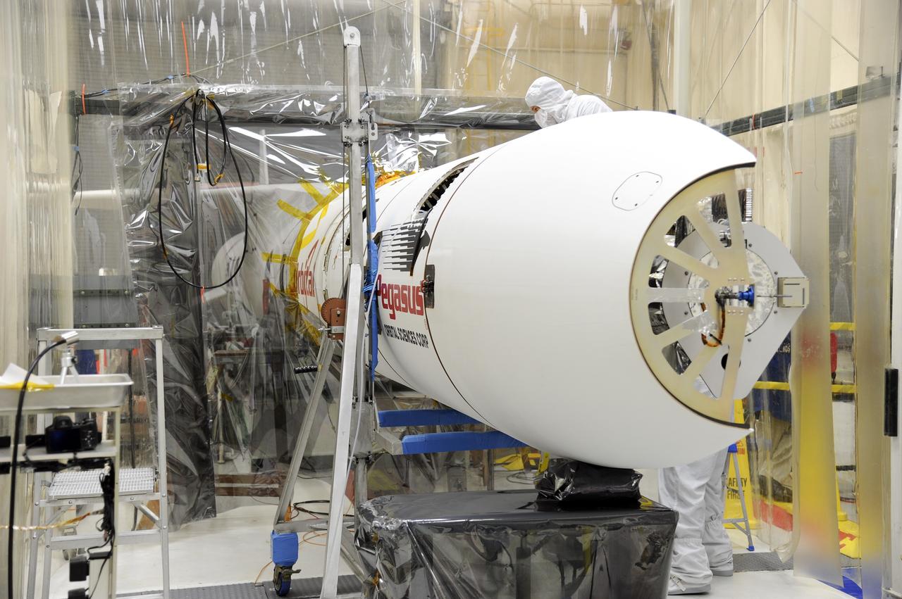 VANDENBERG AFB – Orbital Sciences team members prepare to move the second half of the payload fairing before it is placed over NASA's IRIS spacecraft. The fairing connects to the nose of the Orbital Sciences Pegasus XL rocket that will lift the solar observatory into orbit in June. The work is taking place in a hangar at Vandenberg Air Force Base where IRIS, short for Interface Region Imaging Spectrograph, is being prepared for launch on a Pegasus XL rocket. Scheduled for launch from Vandenberg June 26, IRIS will open a new window of discovery by tracing the flow of energy and plasma through the chromospheres and transition region into the sun’s corona using spectrometry and imaging. IRIS fills a crucial gap in our ability to advance studies of the sun-to-Earth connection by tracing the flow of energy and plasma through the foundation of the corona and the region around the sun known as the heliosphere. Photo credit: NASA/Tony Vauclin